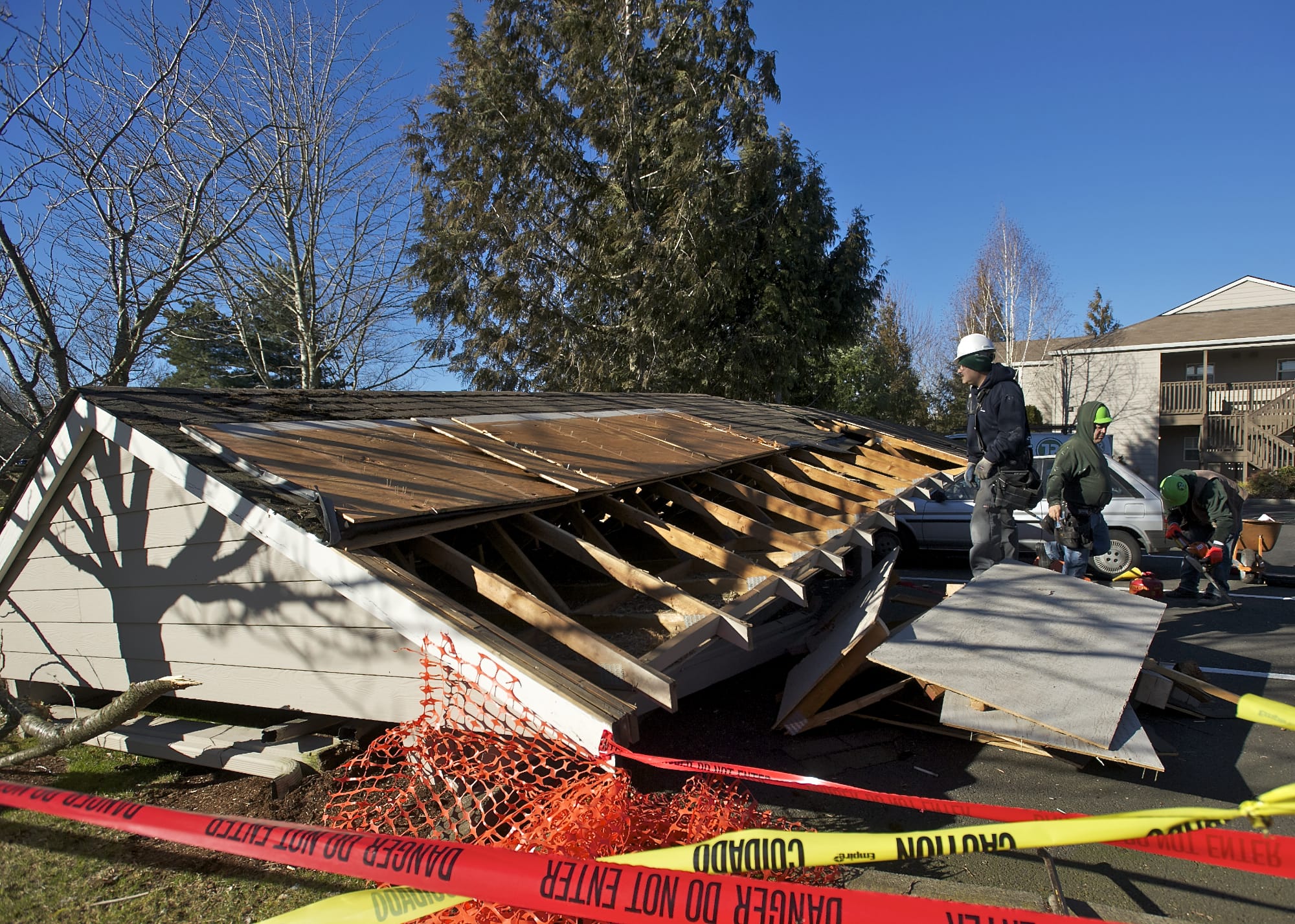 Crews clean up after wind toppled a carport at the Eight Towncenter at Fisher's Landing apartments on Friday.