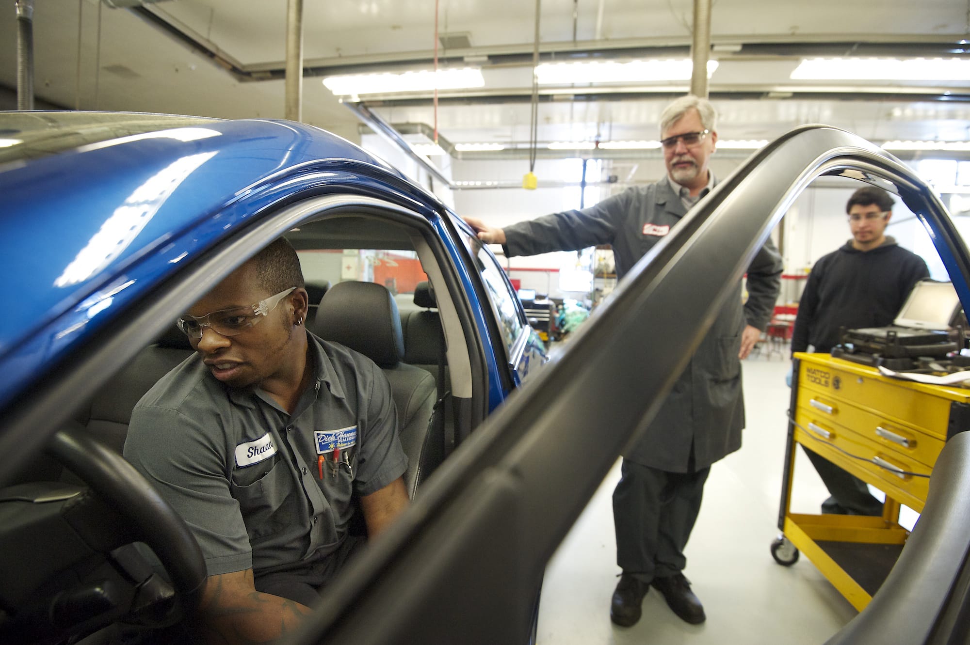 Shaan Grissom, a first-year automotive student at Clark College's Toyota T-TEN automotive technology program, learns from department head Mike Godson how to use a tire pressure monitor system on Wednesday.