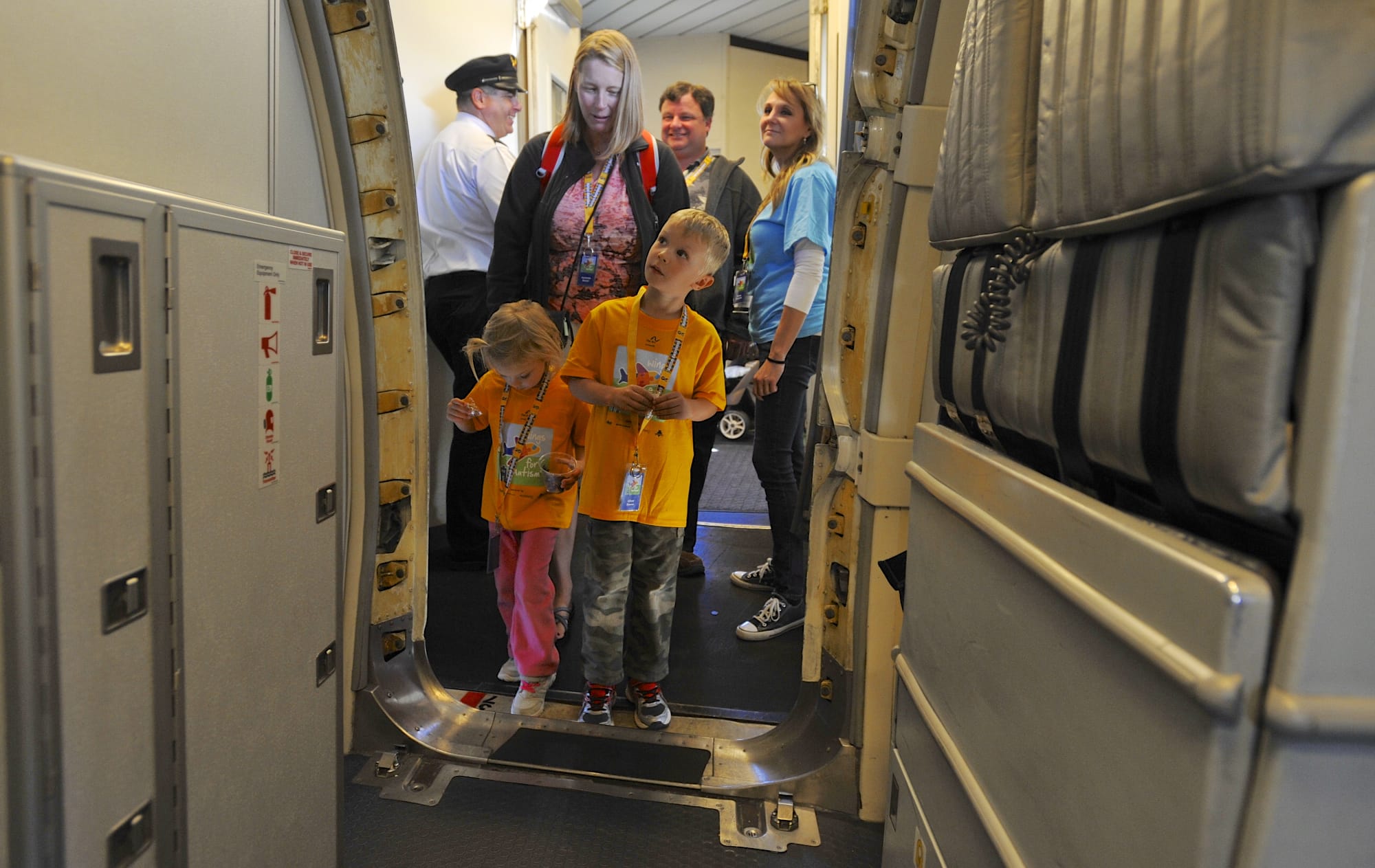 Elliott Beaver, center, and Abby Beaver board the plane as Alaska Airlines hosts a Wings for Autism event at PDX in Portland, Ore., Saturday Sept 26, 2015.