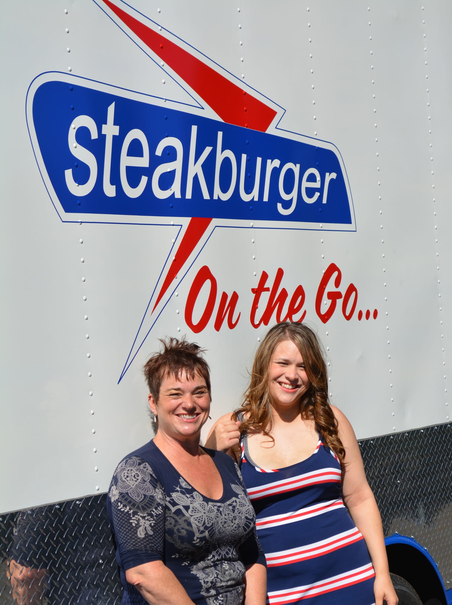 Tina Condon, left, and her daughter Tiffany Castano-Sawyer stand in front of their new food trailer venture, Steakburger on the Go.