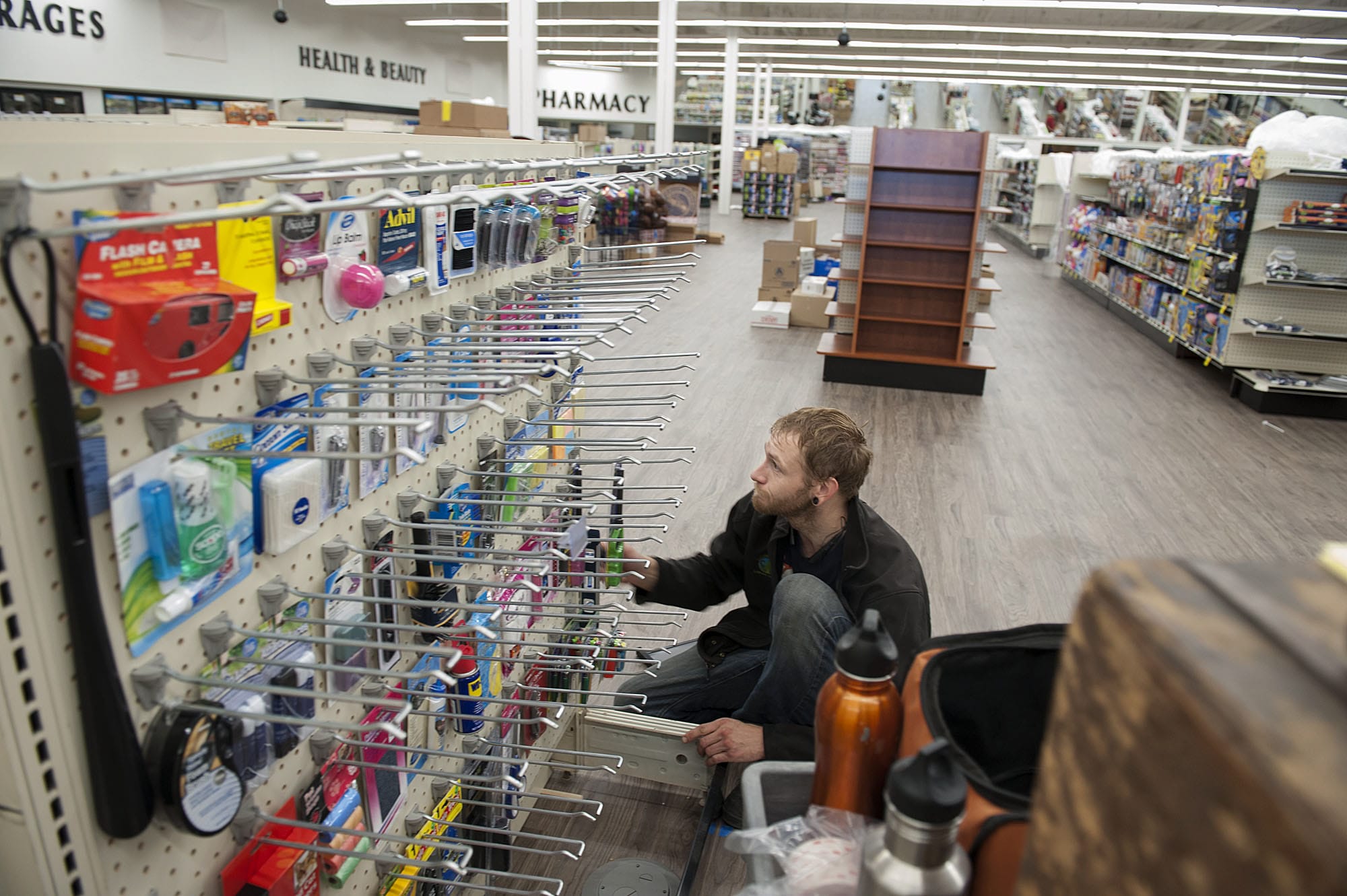 Eric Burgstahler of a Hi-School Pharmacy helps set up a display for merchandise at the company’s new store in the Minnehaha area. The store is set to open Sept. 20, more than a dozen years after Hi-School Pharmacy sold its Clark County stores.