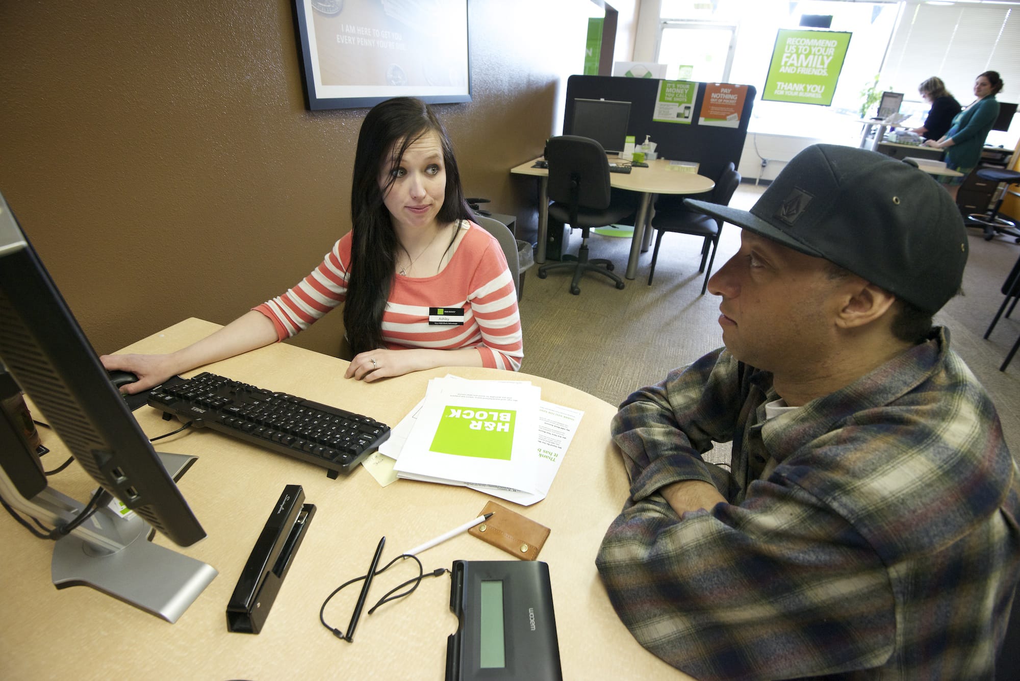 Ashley Bowers, left, a tax associate at H&amp;R Block, helps James Griffin of Vancouver with his tax returns Monday at the tax firm's Main Street office. Griffin, a salesperson, and said his biggest worry every tax season is whether he owes money or not.
