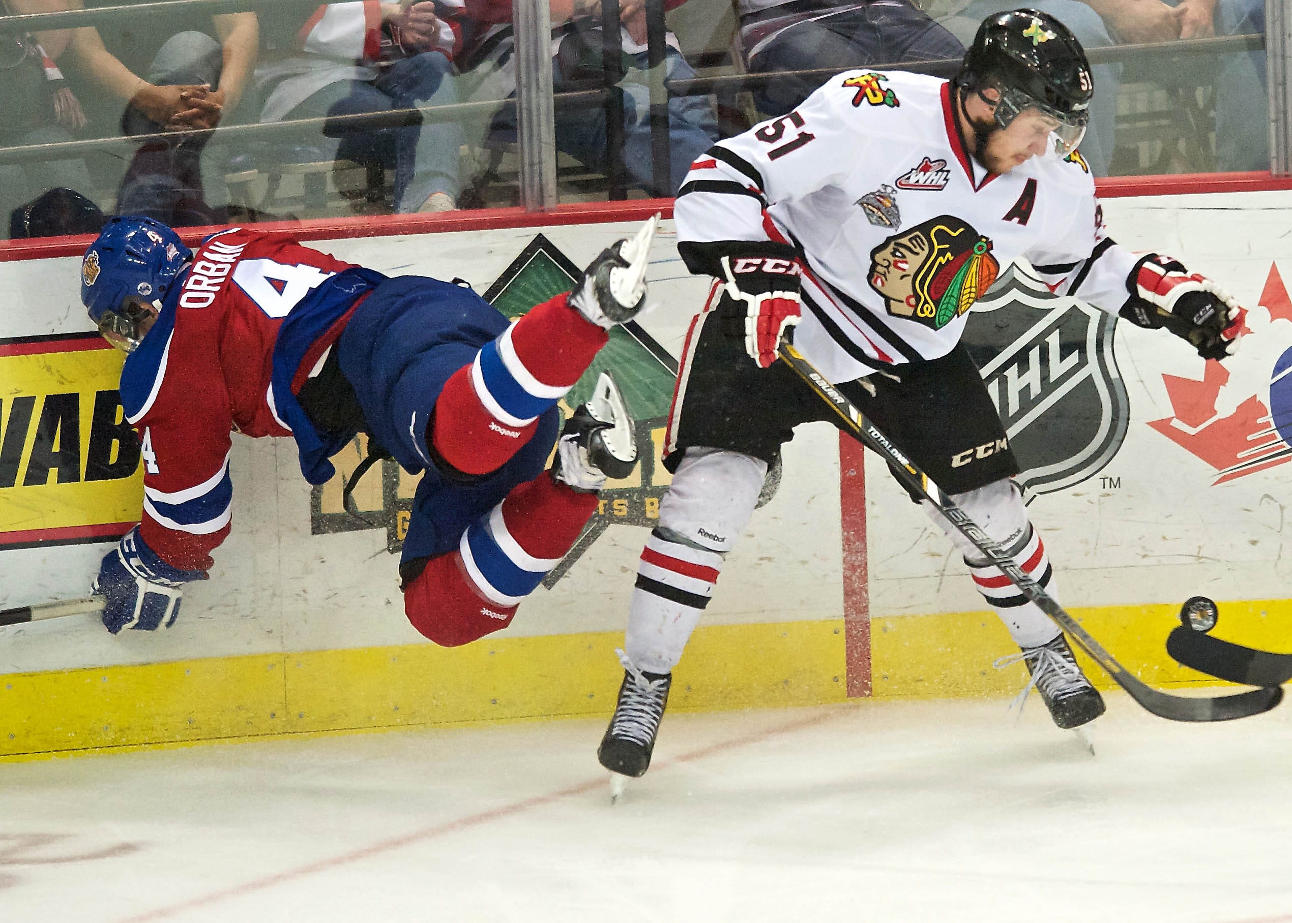 The Winterhawks' Derrick Pouliot checks the Oil Kings' Blake Orban off the puck in the second period of game 7 of the WHL finals at the Veterans Memorial Coliseum on Monday May 12, 2014.