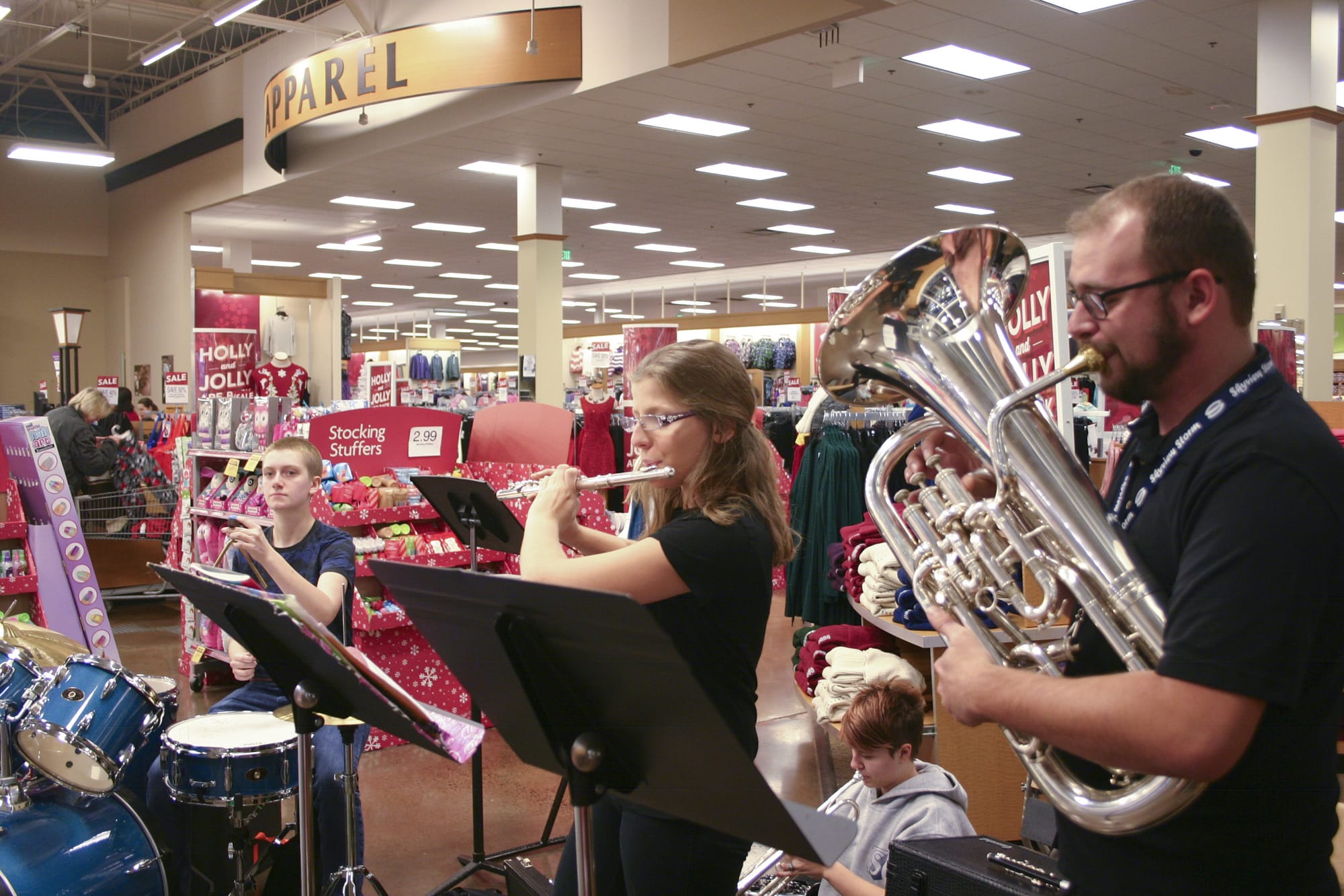 Band Director Tim Heichelheim, right, plays Christmas songs with a group of his students from Skyview High School on Saturday at the Salmon Creek Fred Meyer.