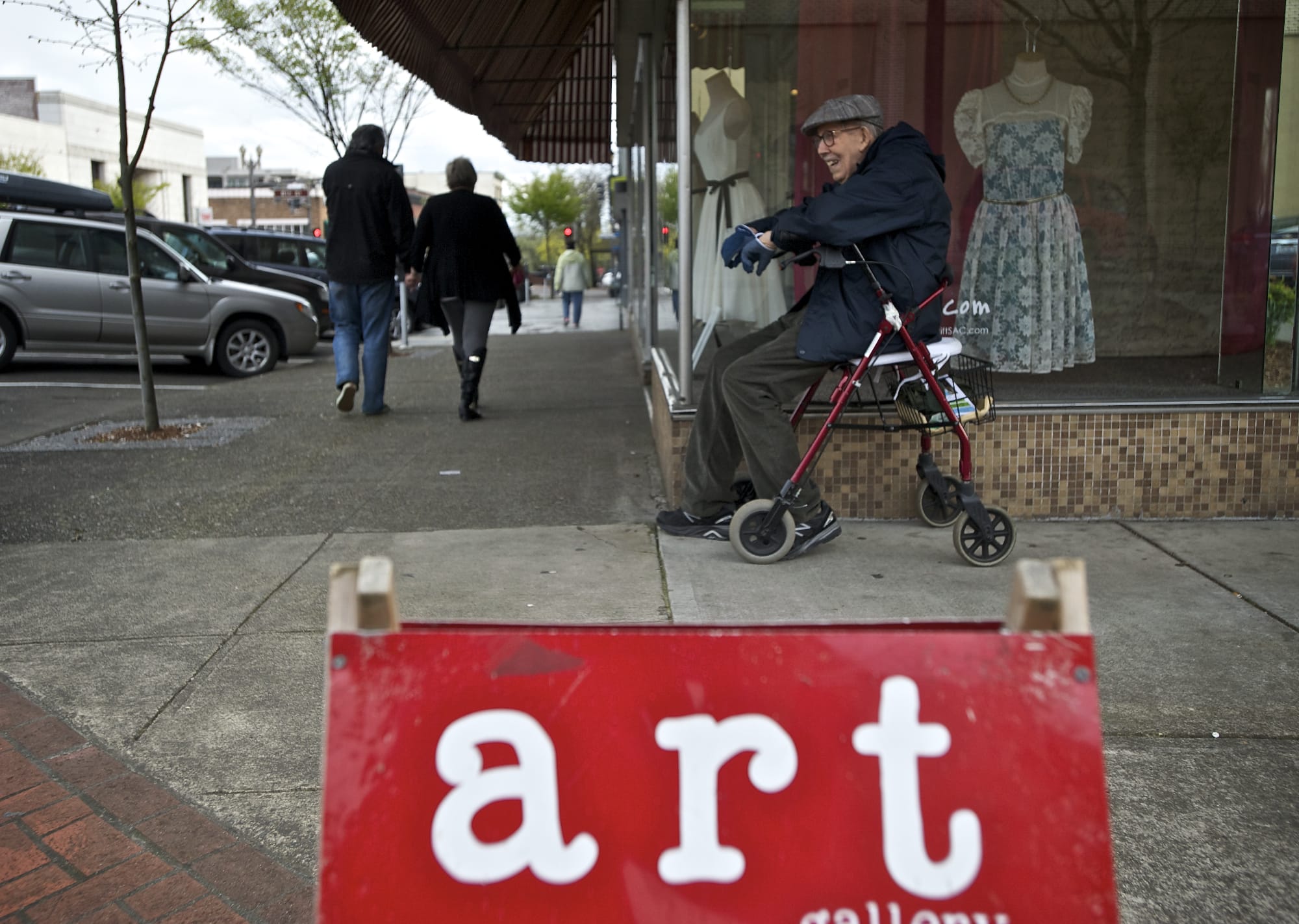 Painter and Southwest Washington Watercolor Society member John Beckman, 86, waits for a ride near a sign directing people to Gallery 360 at Main and Ninth streets during First Friday Downtown art walk.