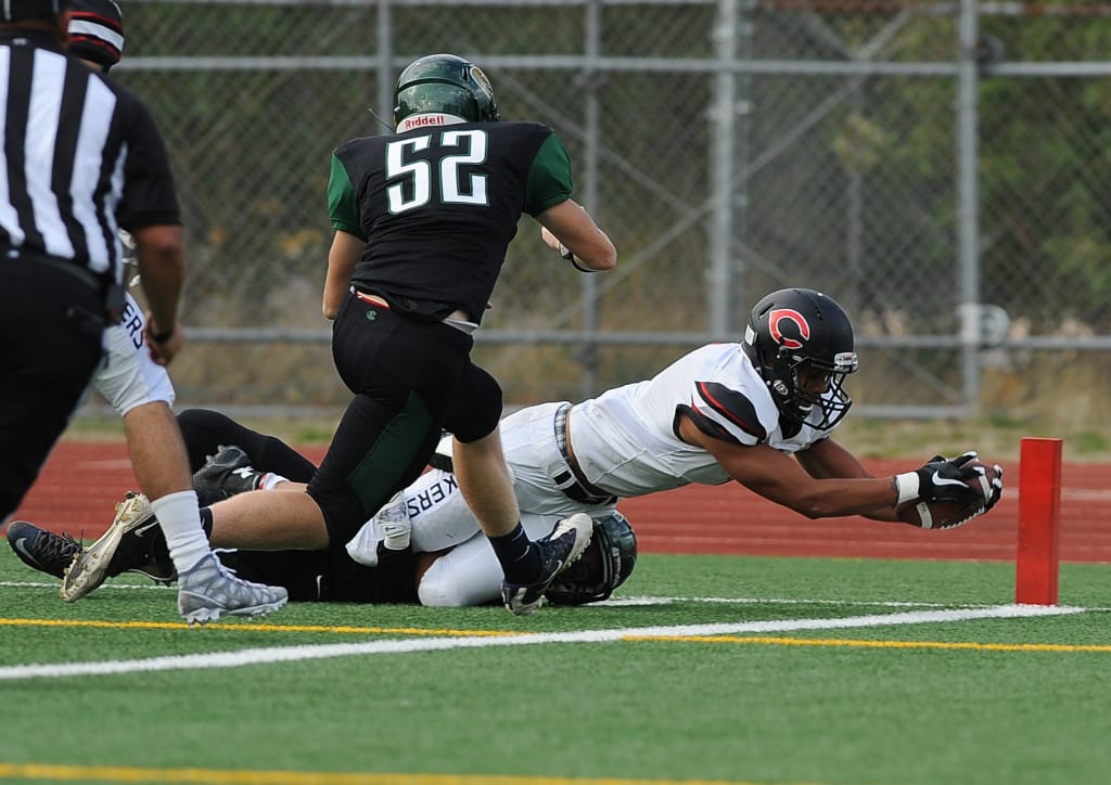 Camas&#039;s Manase Nguamo scores a touchdown as he is pursued by and Evergreen player not identified in the roster at McKenzie Stadium in Vancouver Friday September 25, 2015.