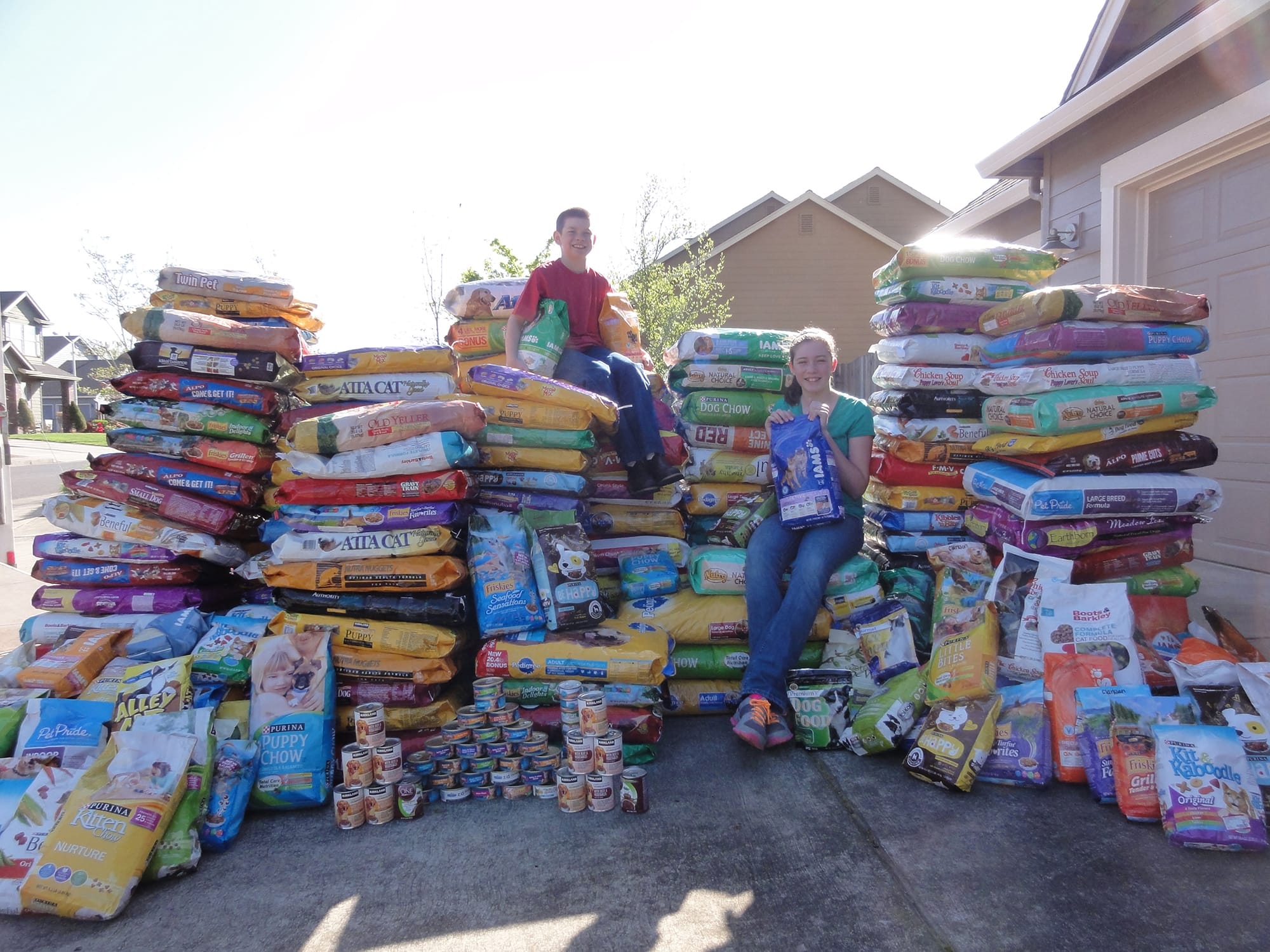 Fisher-Mill Plain: Siblings Jared Wallingford and Alicia Wallingford stand with their donations to the Humane Society for Southwest Washington, part of the family's annual Julie Reamer Memorial Pet Food Drive, which gathers pet food during a competition between three Vancouver schools.