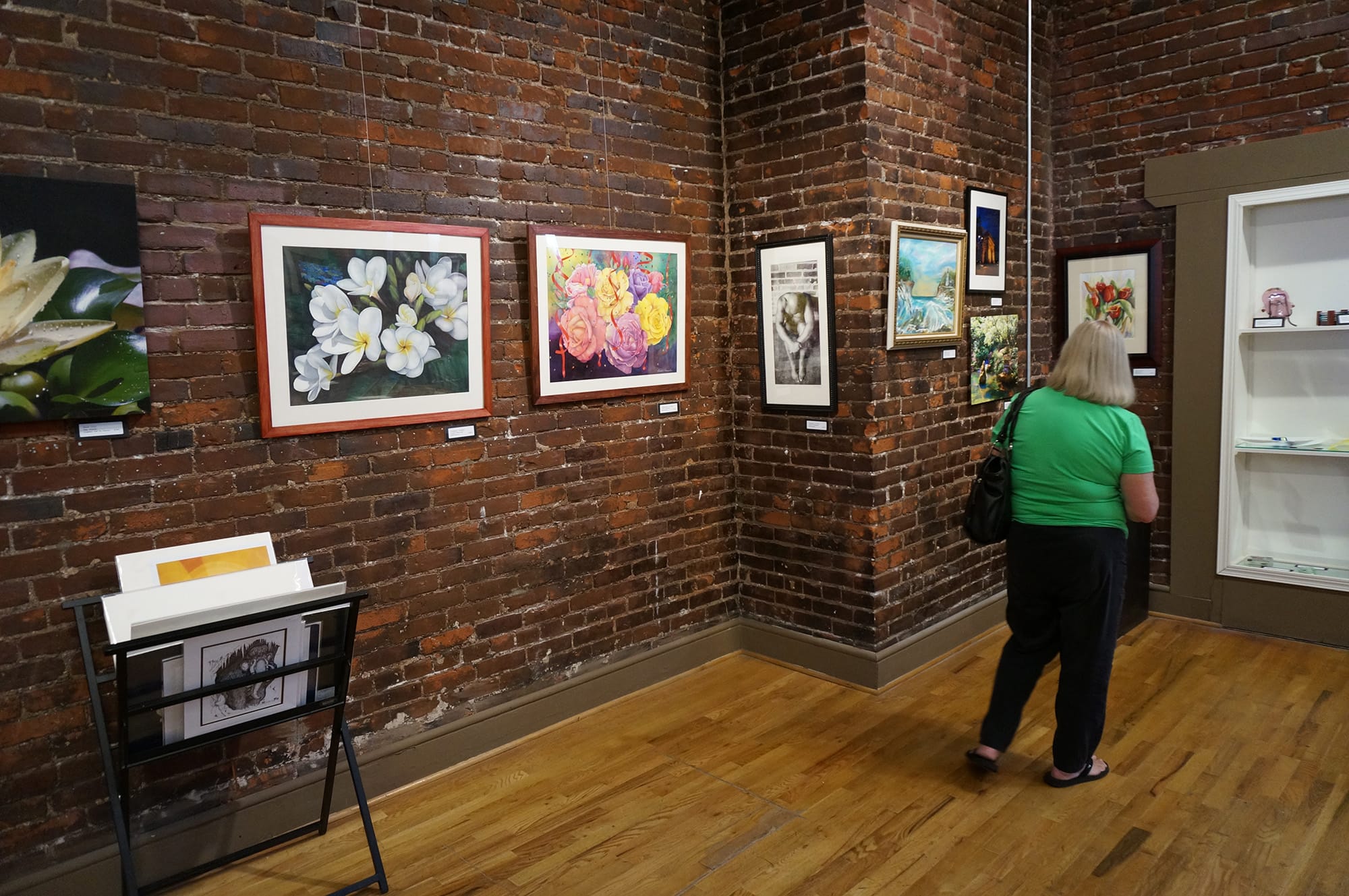 A visitor walks through Gallery 360's Art in the Heart exhibit earlier this month, the second-to-last art show at the Ninth Street location before the gallery closes in early September.
