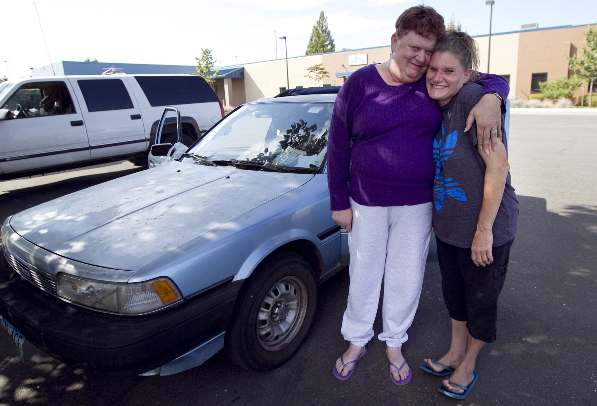 C-Tran bus driver Kerry Erving, left, gives a squeeze to Amanda Snapp, whom she discovered living in her car in the shared parking lot of Share and the Council for the Homeless.