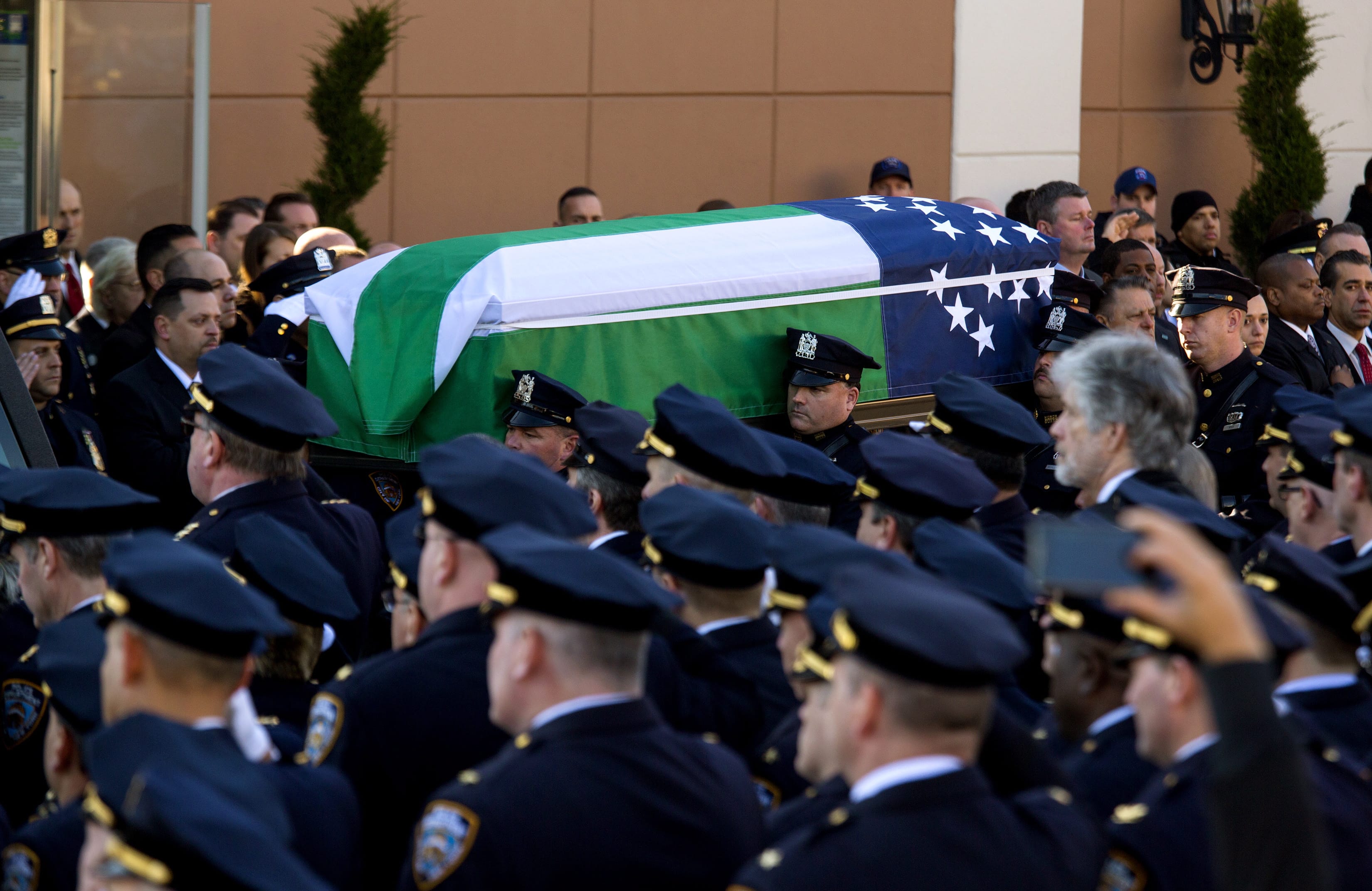 The body of New York City police officer Rafael Ramos is brought from Christ Tabernacle Church draped in an NYPD flag after his funeral Saturday in the Glendale section of Queens, where he was a church member. Ramos and his partner, officer Wenjian Liu, were killed Dec. 20 as they sat in their patrol car on a Brooklyn street.
