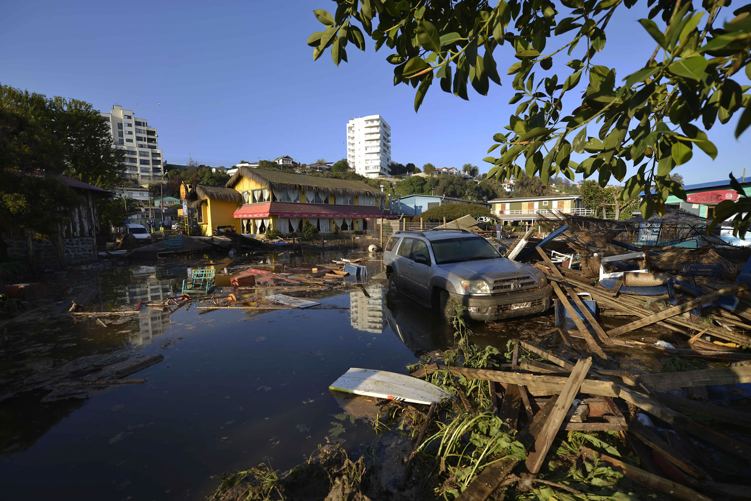 A car is surrounded by debris Thursday in a flooded street after an earthquake-triggered tsunami hit Concon, Chile. Several coastal towns were flooded from small tsunami waves set off by late Wednesday's magnitude-8.3 earthquake, which shook the Earth so strongly that rumbles were felt across South America.