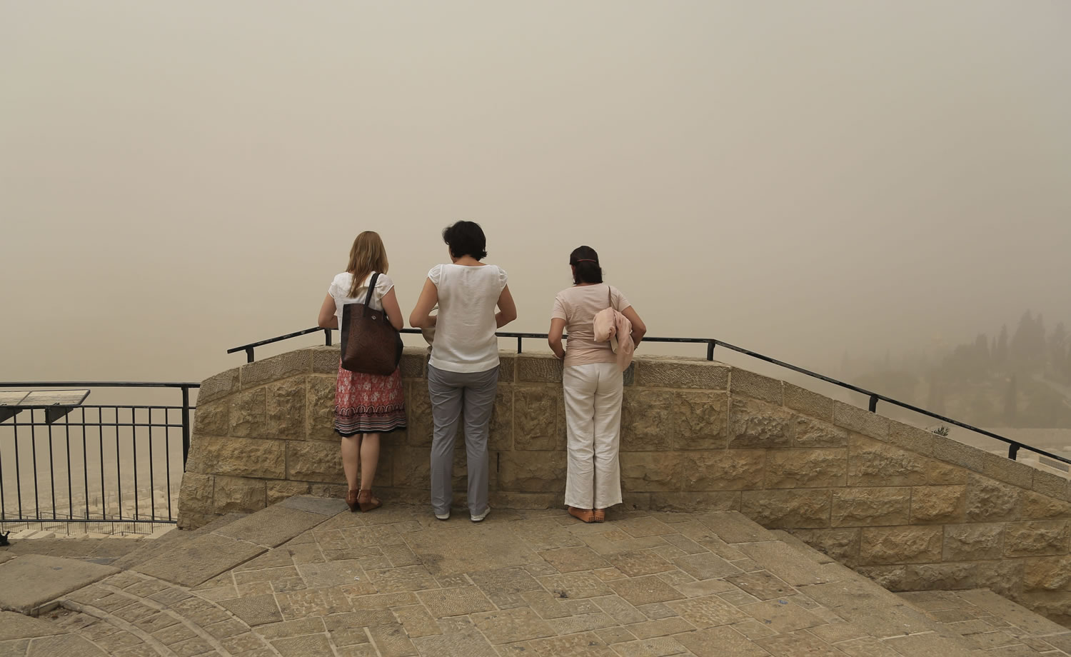 Women view scenery obscured by a sandstorm as they visit Jerusalem's Old City on Tuesday. The unseasonal sandstorm has hit the Middle East, reducing visibility and sending hundreds to hospitals with breathing difficulties.