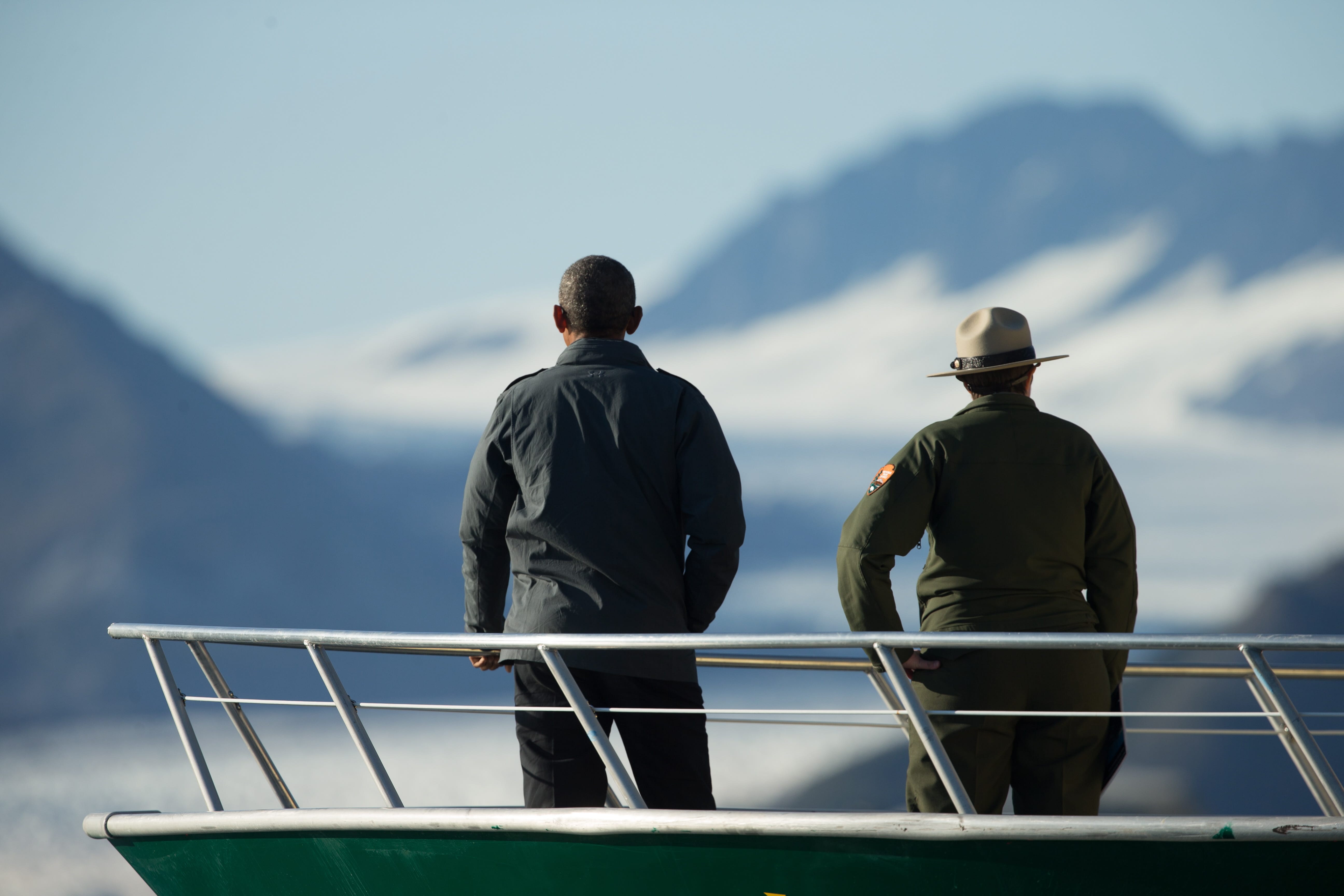 President Barack Obama, accompanied by a National Park Service employee looks at Bear Glacier, which has receded 1.8 miles in approximately 100 years, while on a boat tour to see the effects of global warming in Resurrection Cove, Tuesday in Seward, Alaska. Obama is on a historic three-day trip to Alaska aimed at showing solidarity with a state often overlooked by Washington, while using its glorious but changing landscape as an urgent call to action on climate change.