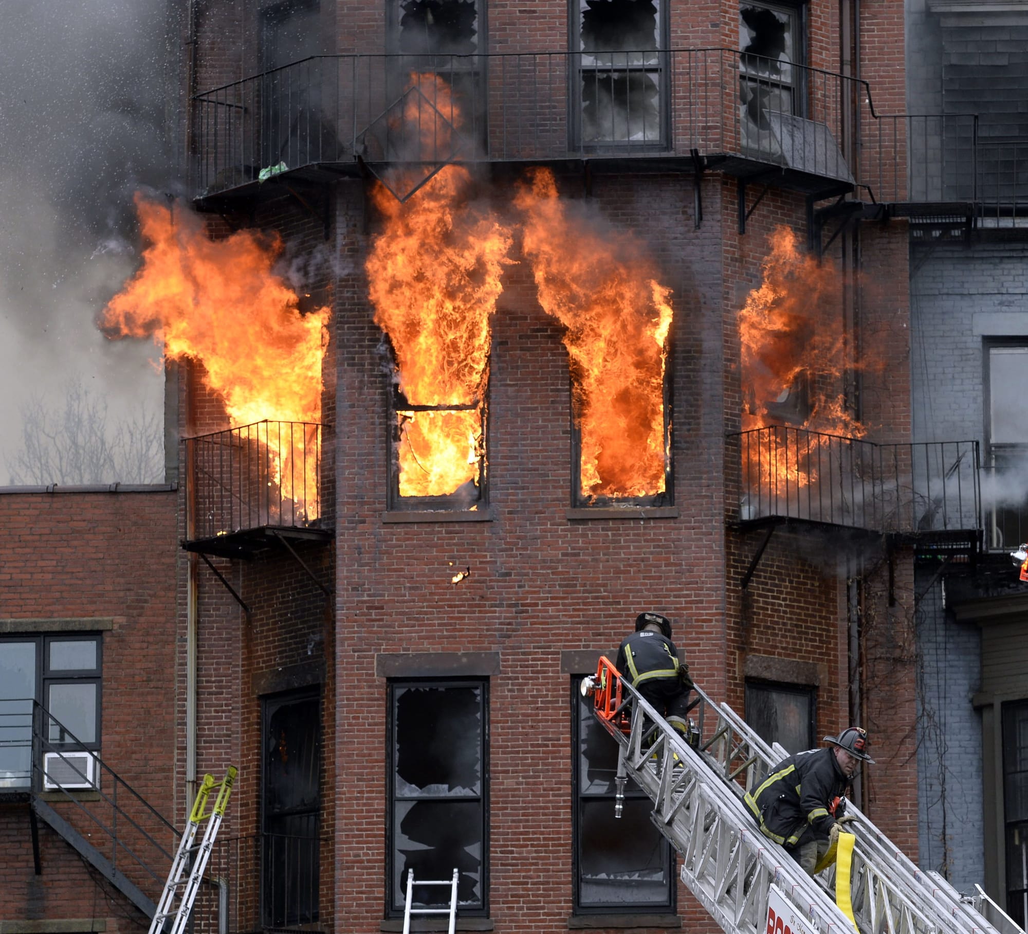 Flames pour from the windows of an apartment building on Wednesday in Boston. The cause of the fire was under investigation and District Attorney Daniel F.