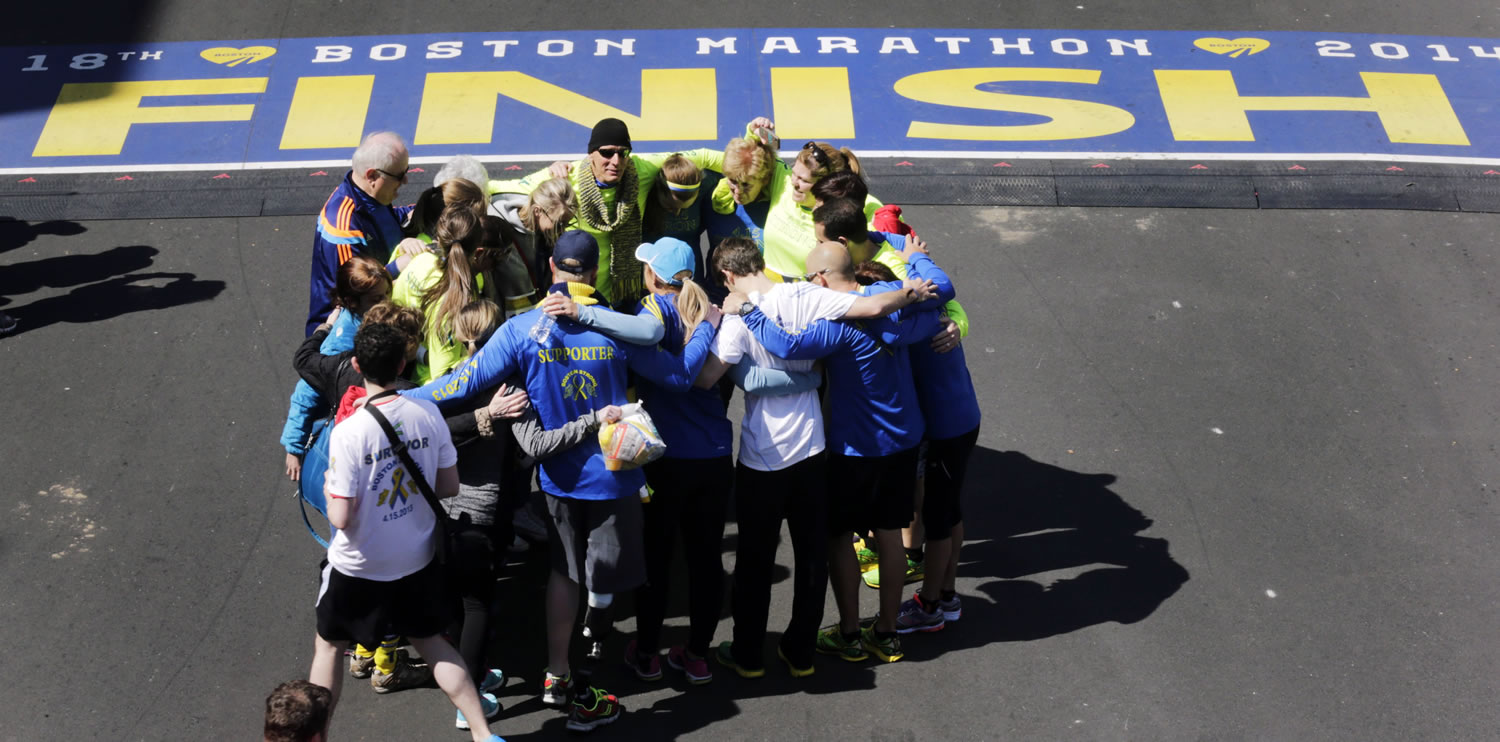 Boston Marathon bombing survivors, family and friends gather in circle after crossing the finish line of the marathon during a Tribute Run on Saturday in Boston.