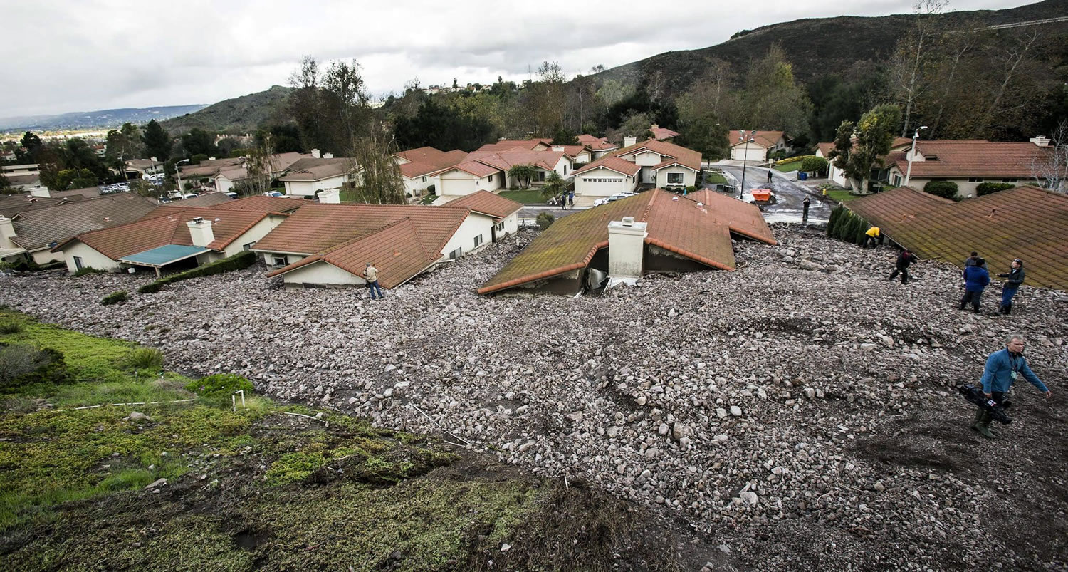Debris and rocks fill the backyards of homes along San Como Lane on Friday in Camarillo Springs, Calif.