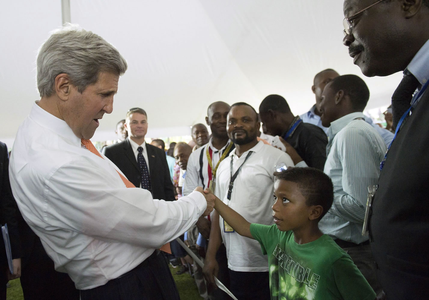 U.S. Secretary of State John Kerry greets an unidentified boy Saturday during meetings with U.S. embassy staff and families at the Chief of Mission Residence in Kinshasa, Democratic Republic of Congo.