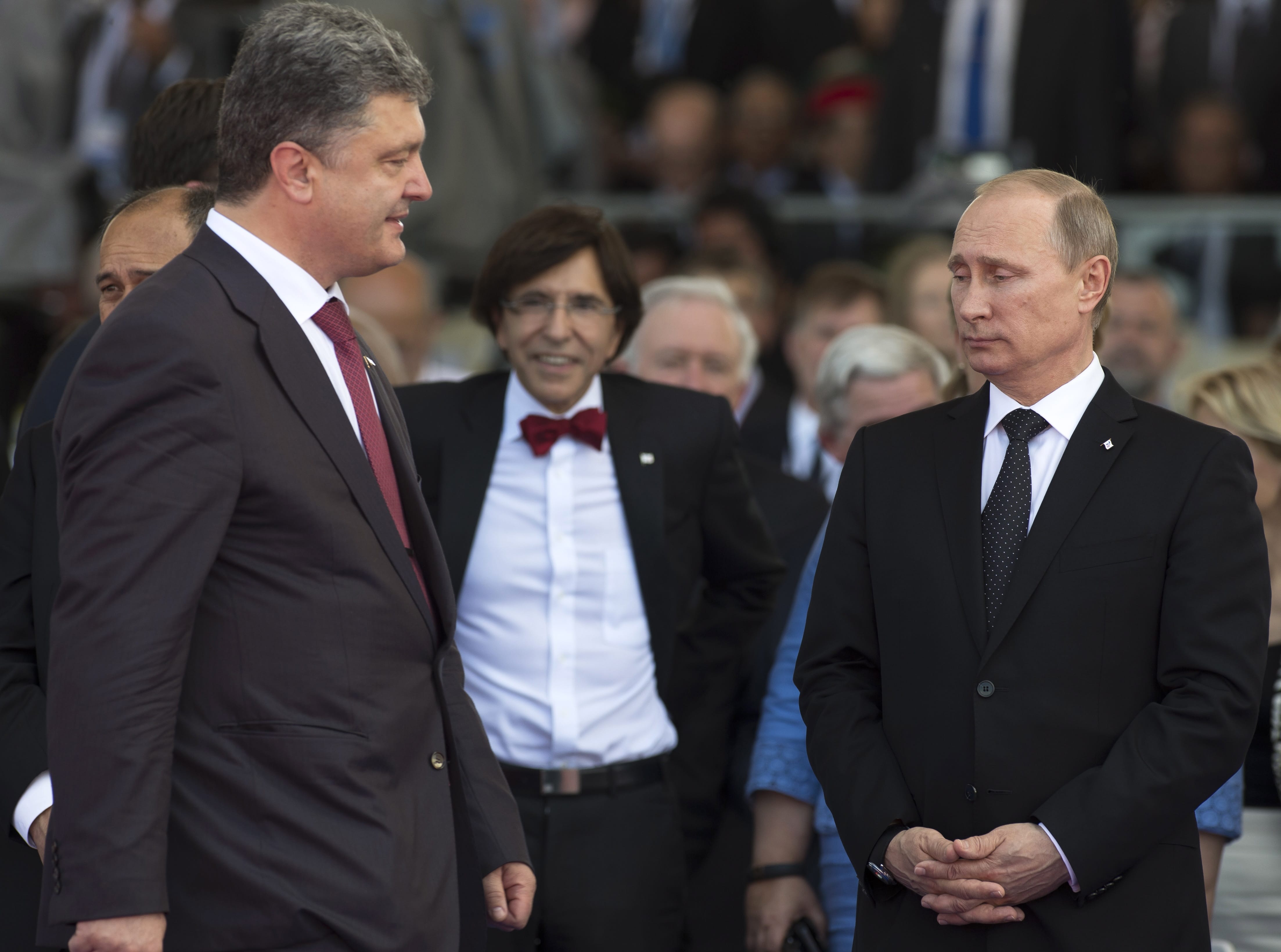 Ukraine's President-elect Petro Poroshenko, left, walks past Russian President Vladimir Putin, right, on Friday during D-Day ceremonies in Ouistreham, France.