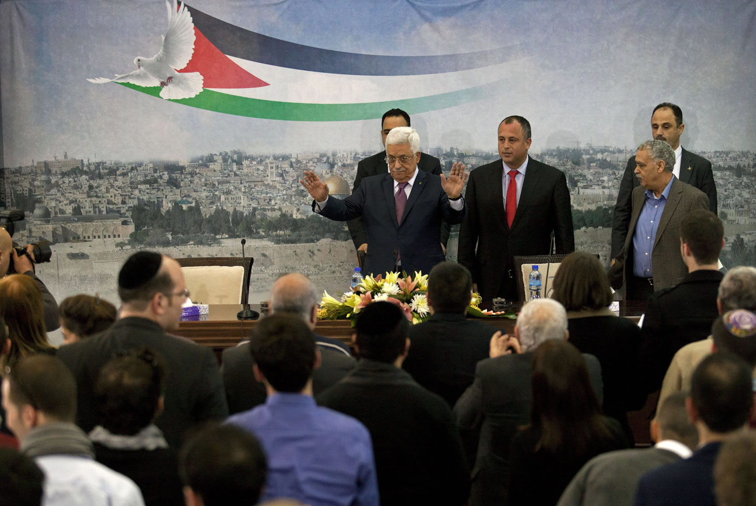 Palestinian President Mahmoud Abbas, top left, and Israeli Labor party lawmaker Hilik Bar, top second from left, arrive for a meeting Sunday with a delegation of mostly Israeli university students and activists in dovish political parties, at his compound in the West Bank city of Ramallah.