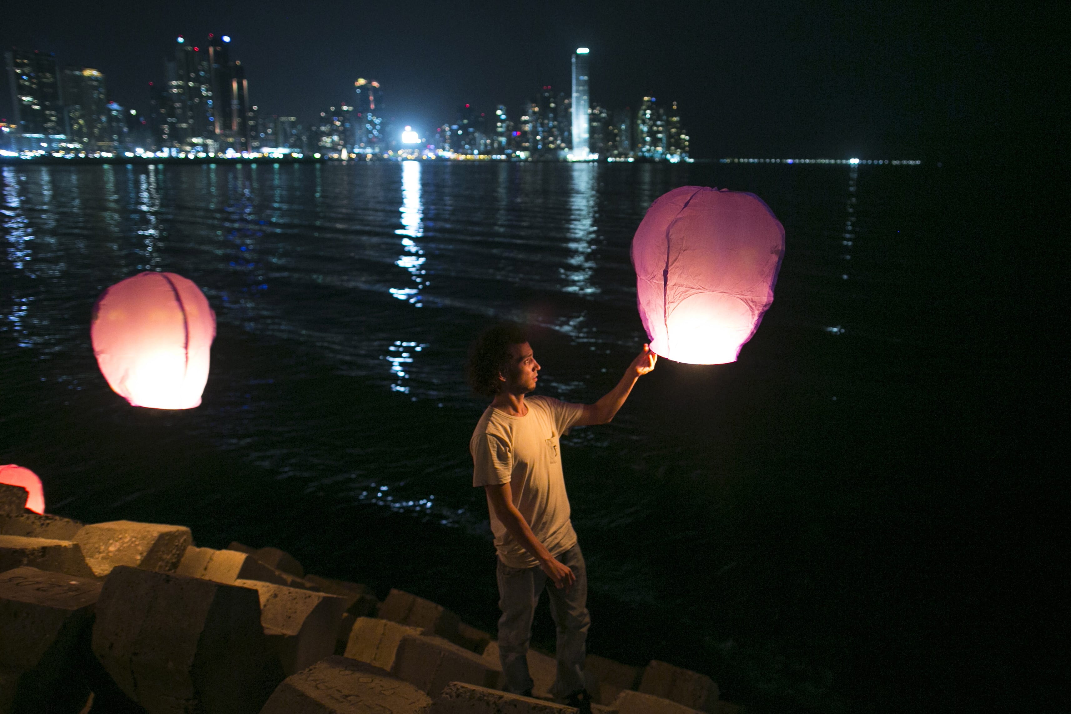 People prepare to release paper lanterns in the Panama City Bay as part of a public event held as a tribute to the victims of the US invasion of  Panama one day before the 25th anniversary of the military operation in Panama City, Friday, Dec. 19, 2014. On Dec. 20, 1989, US armed forces in an operation code-named Just Cause, invaded Panama to overthrow Panama's dictator Manuel Antonio Noriega and the Panamanian Defense Forces were dissolved.