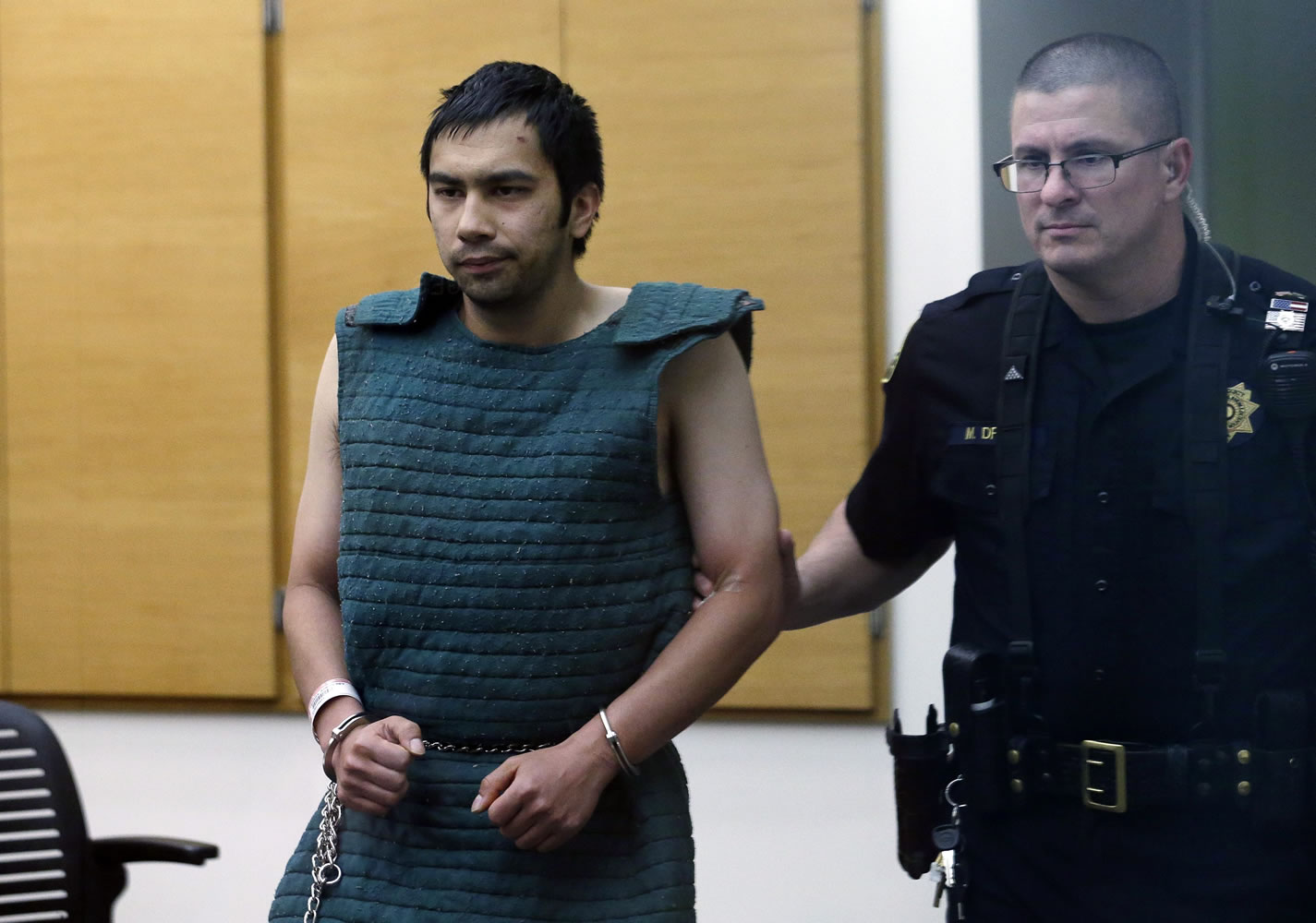 Shooting suspect Aaron Ybarra, left, is led in chains to a court hearing at a King County Jail courtroom Friday in Seattle.