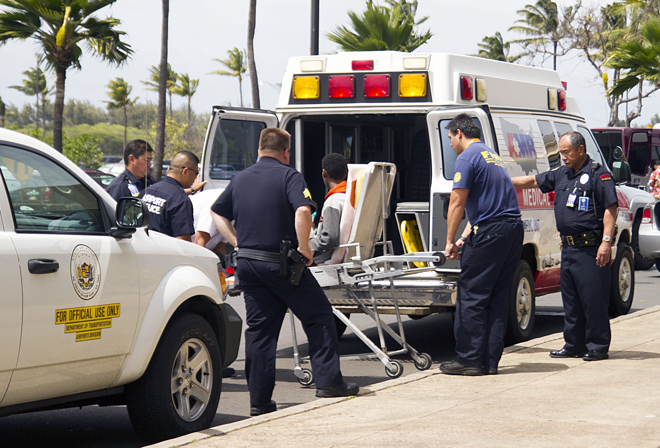 A 15-year-old boy who stowed away in the wheel well of a flight from San Jose, Calif., to Maui, on stretcher at center, is loaded into an ambulance at Kahului Airport in Kahului, Maui, Hawaii, on Sunday afternoon.