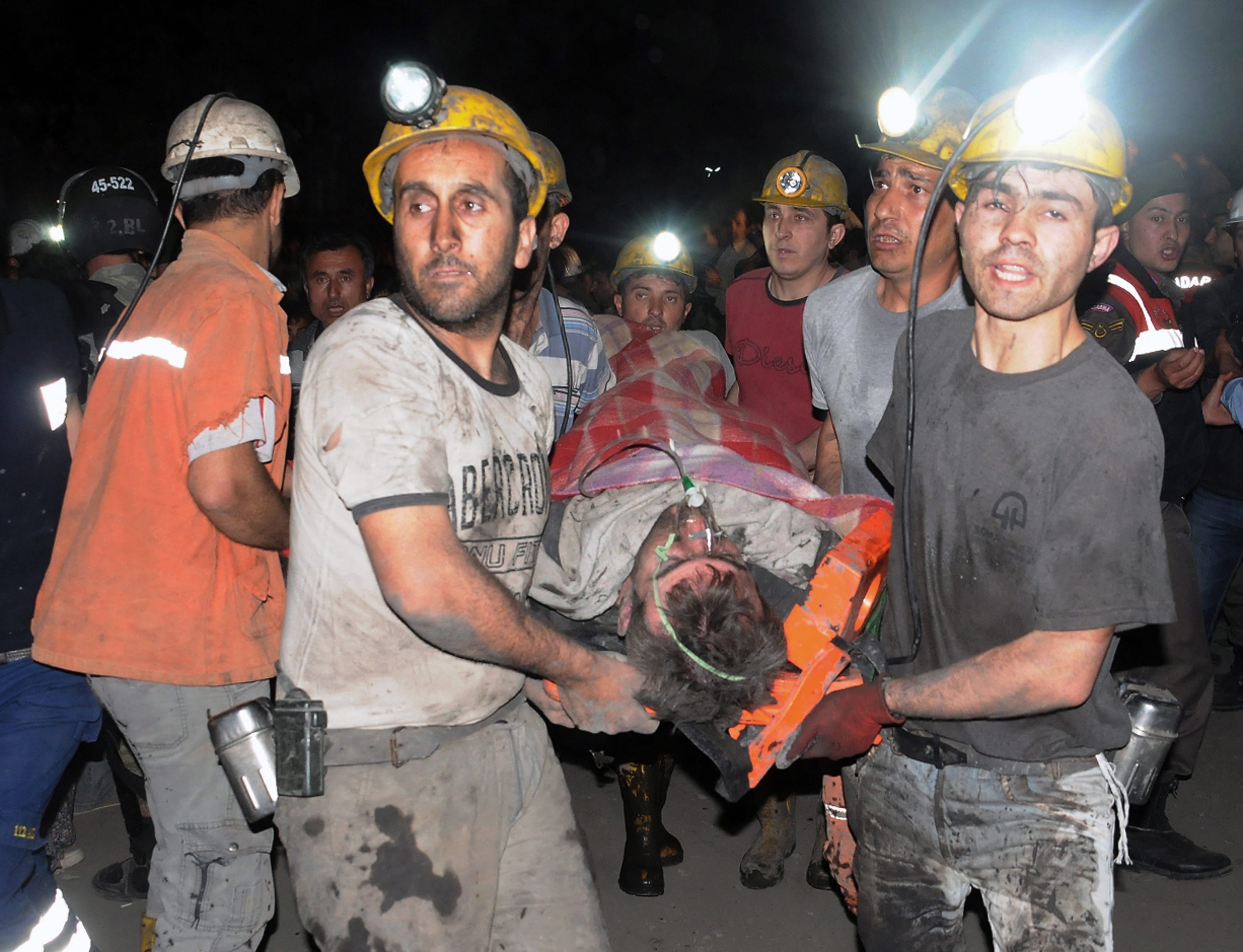 Miners carry a rescued miner after an explosion and fire at a coal mine killed at least 17 miners and left up to 300 workers trapped underground, in Soma, in western Turkey, on Tuesday.