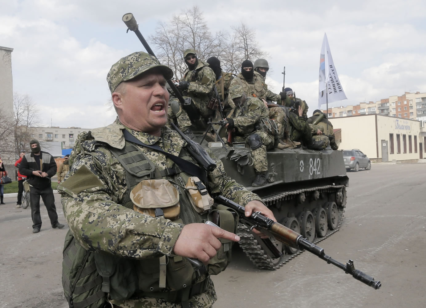 A pro-Russian gunman clears the way for a combat vehicle with gunmen on top in Slovyansk, Ukraine, on Wednesday.