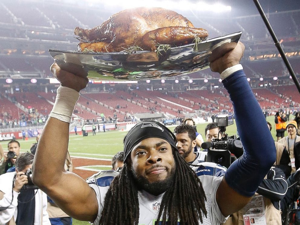 Seattle Seahawks cornerback Richard Sherman holds a turkey aloft after a Thanksgiving Day game against San Francisco.