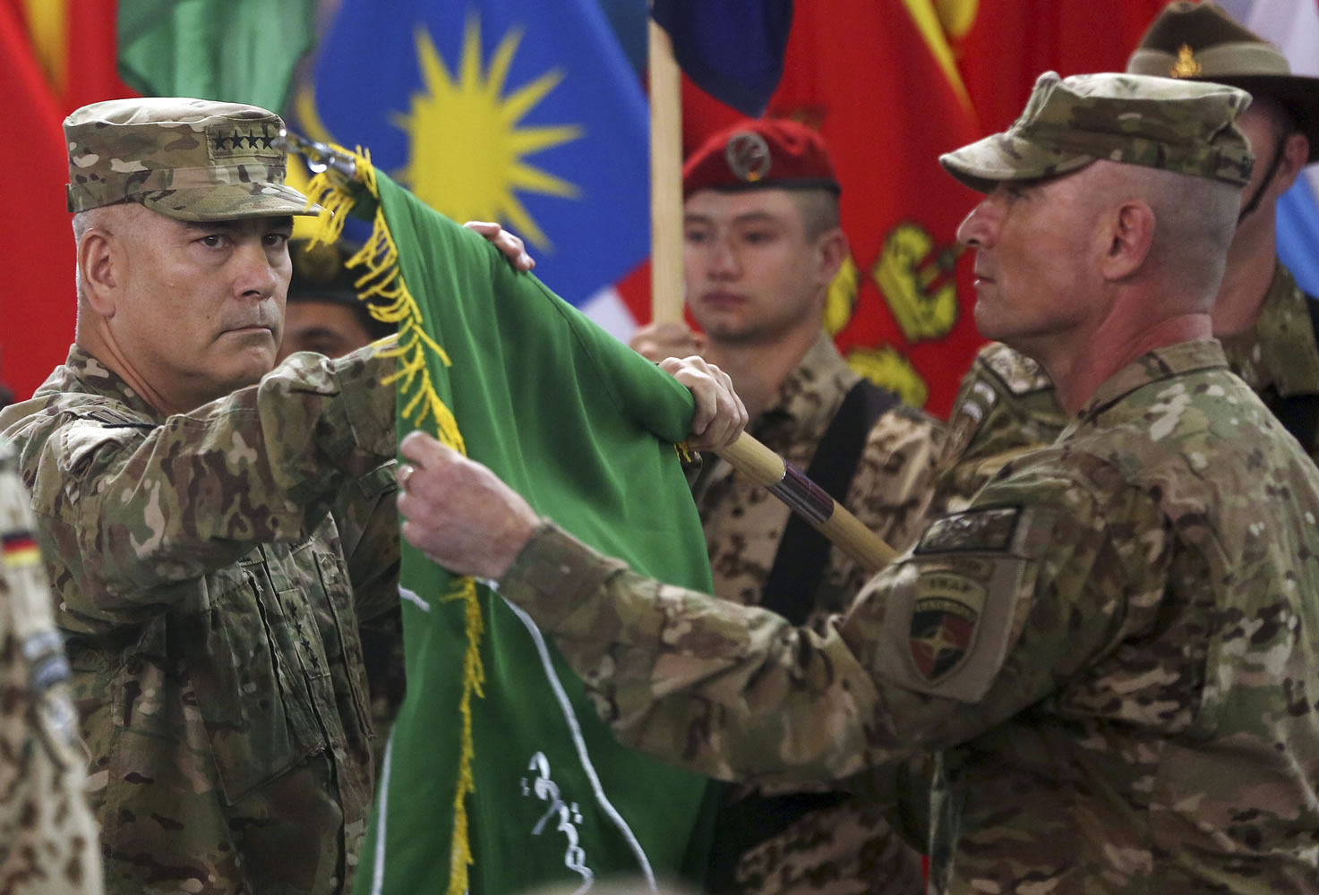 Commander of the International Security Assistance Force, Gen. John Campbell, left, and Command Sgt. Maj. Delbert Byers open the &quot;Resolute Support&quot; flag Sunday during a ceremony at the ISAF headquarters in Kabul, Afghanistan. The United States and NATO formally ended their war in Afghanistan on Sunday with the ceremony at their military headquarters in Kabul as the insurgency they fought for 13 years remains as ferocious and deadly as at any time since the 2001 invasion that unseated the Taliban regime following the Sept.