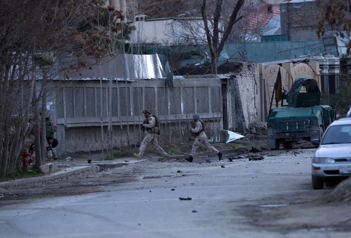 Afghan police and special forces run Friday as they surround the area after four suicide bombers armed with assault rifles and hand grenades attacked an &quot;office of foreigners&quot; in a southwestern neighborhood of Kabul, Afghanistan.