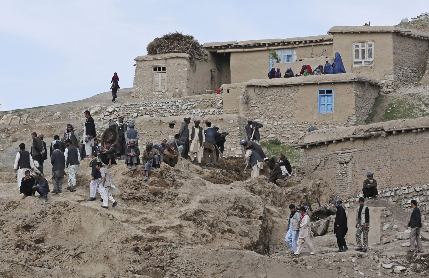 Survivors search for their relatives' bodies at the site of Friday's landslide that buried Abi Barik village in Badakhshan province, northeastern Afghanistan, on Monday.