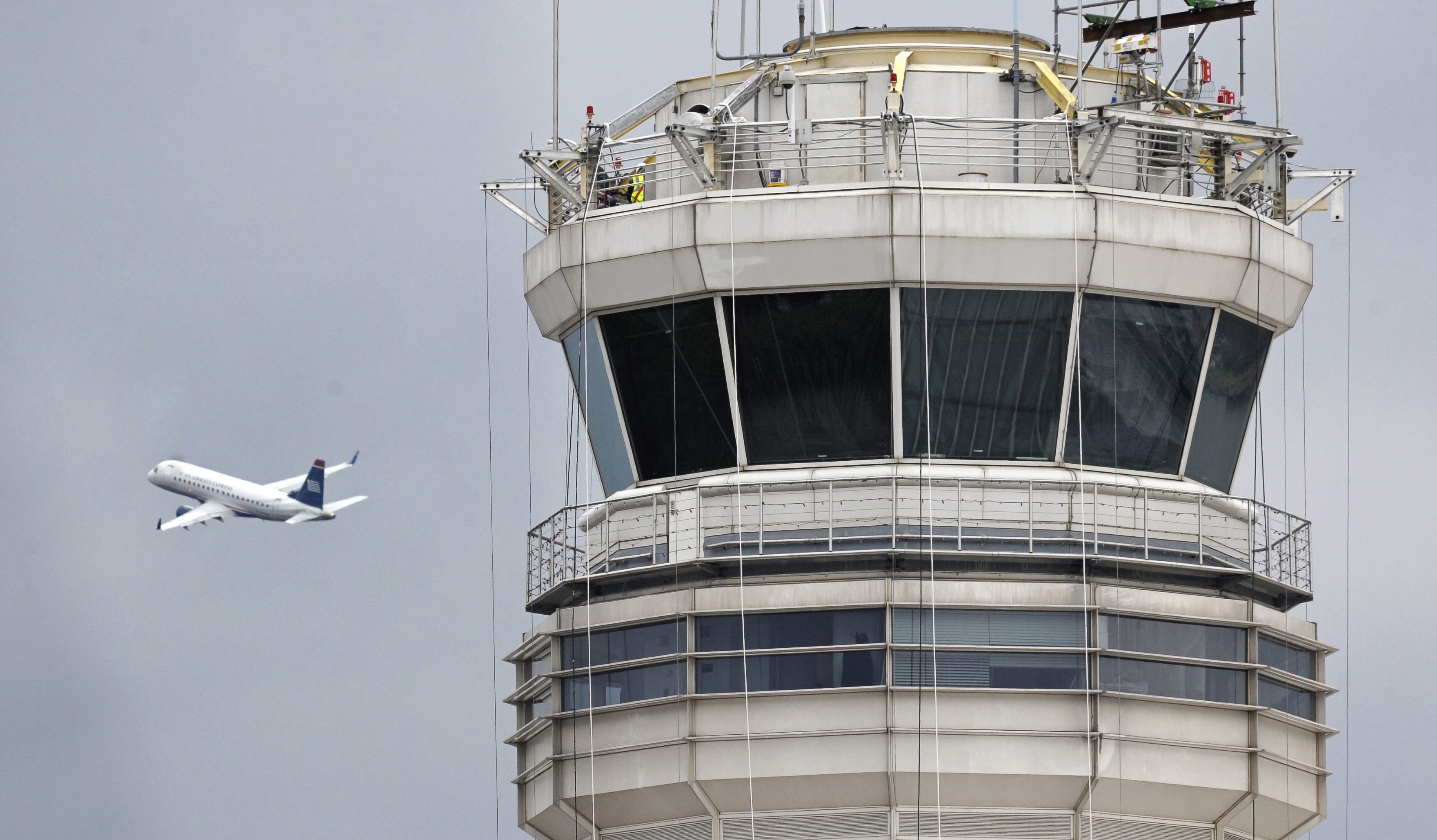 Associated Press files
A jet flies past the control tower at Washington's Ronald Reagan National Airport. Two planes landed at the airport without aid because the lone controller had fallen asleep.