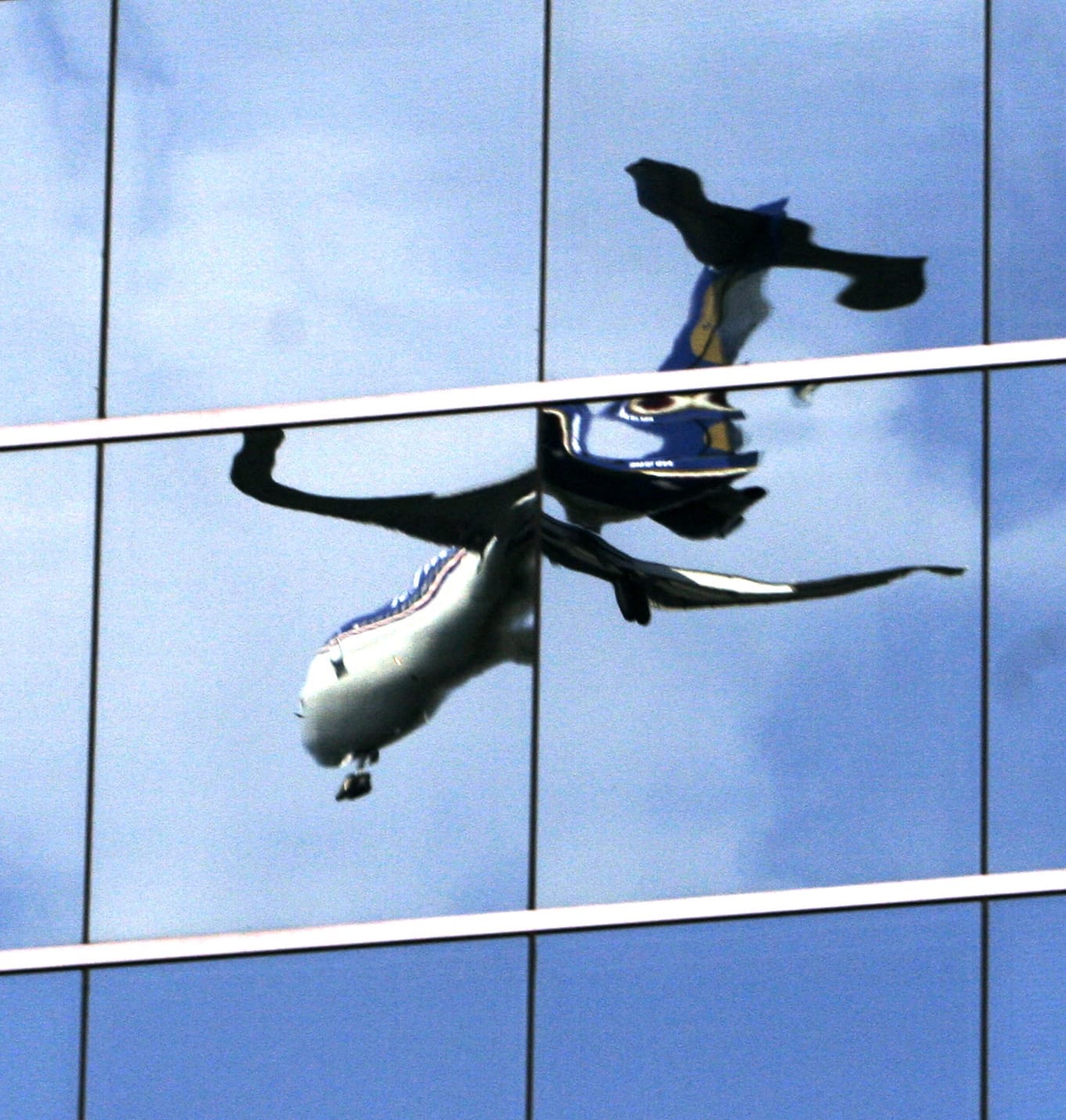 A twisted reflection of a passenger jet is reflected in the mirrored windows of an office building as it lands at Washington's Reagan National Airport in 2007 in Roslyn, Va.