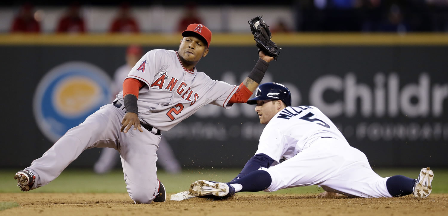 Los Angeles Angels shortstop Erick Aybar (2) and Seattle Mariners' Brad Miller look up for the call on Miller's stolen base at second base in the sixth inning of a baseball game Tuesday, May 27, 2014, in Seattle.
