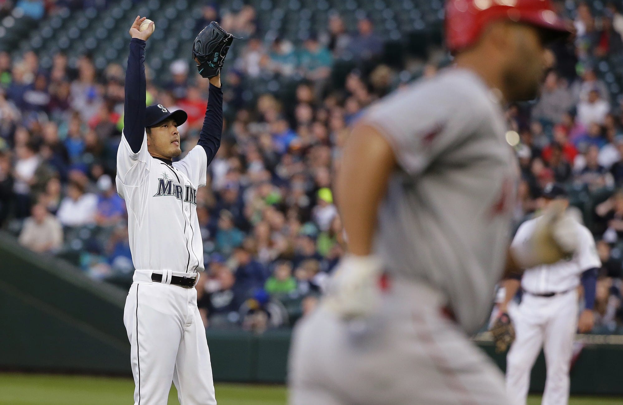 Seattle Mariners starting pitcher Hisashi Iwakuma, left, stretches as Los Angeles Angels' Albert Pujols, right, rounds the bases after hitting a two-run home run in the first inning Wednesday, April 8, 2015, in Seattle. (AP Photo/Ted S.