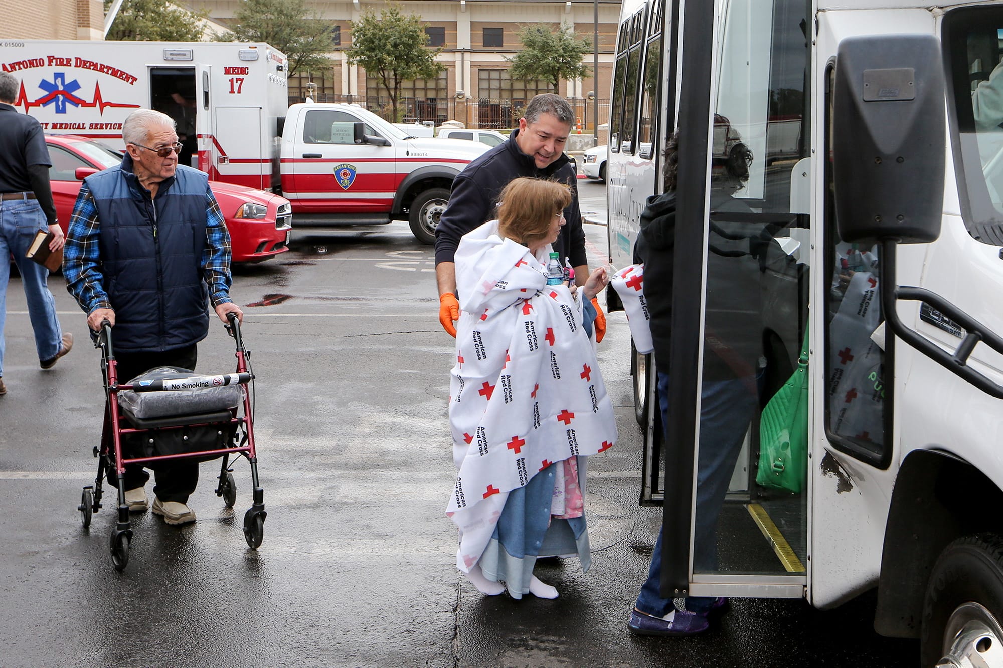 Residents of the Wedgwood Senior Apartments are moved to other locations after being evacuated to Churchill High School following a three-alarm fire at the apartments, Sunday, Dec. 28, 2014 in San Antonio, Texas.