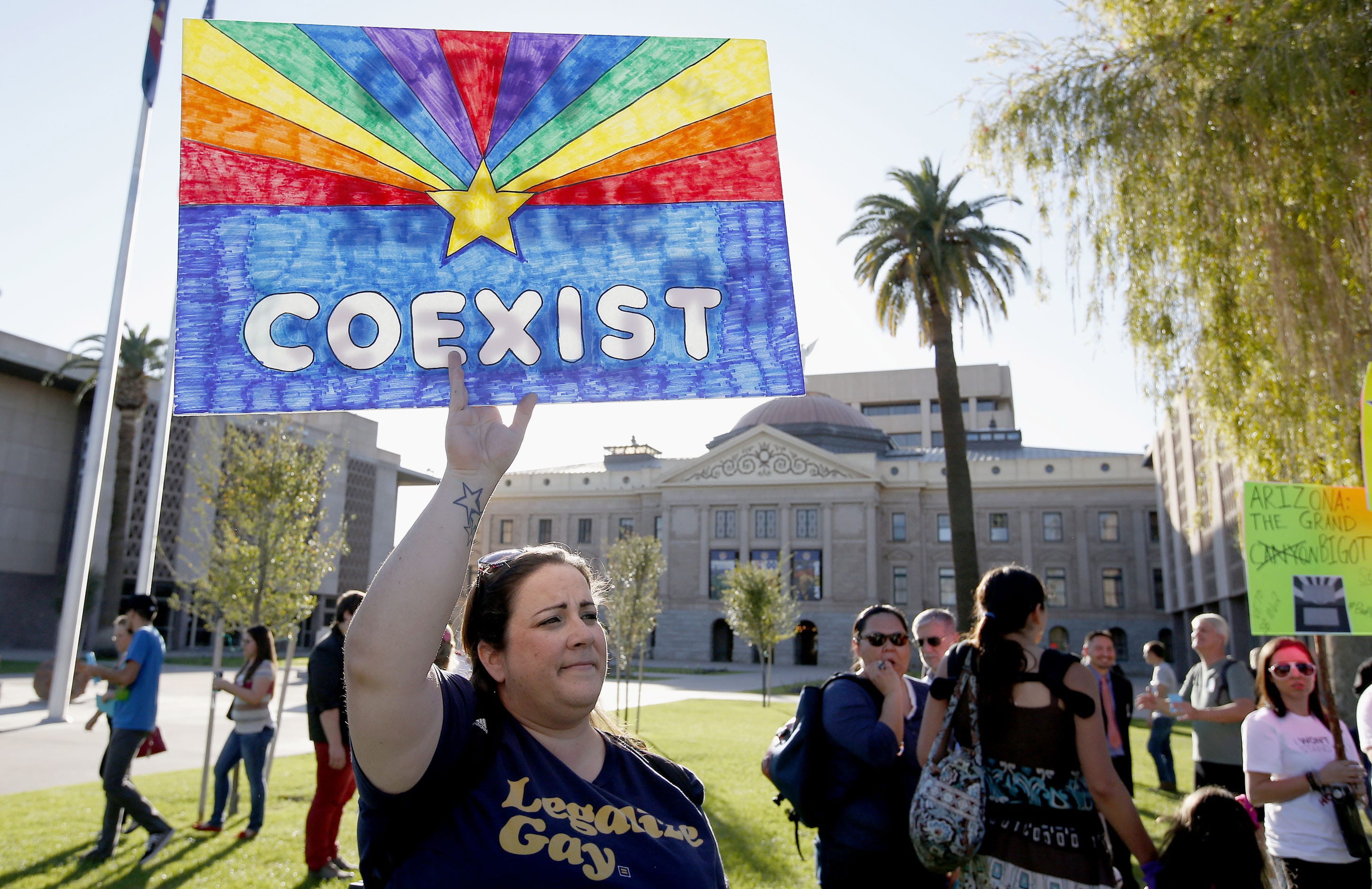 Jo Beaudry holds up a sign as she joins nearly 250 gay-rights supporters to protest SB1062 at the Arizona Capitol  on Friday in Phoenix. The protesters  demanded Gov.