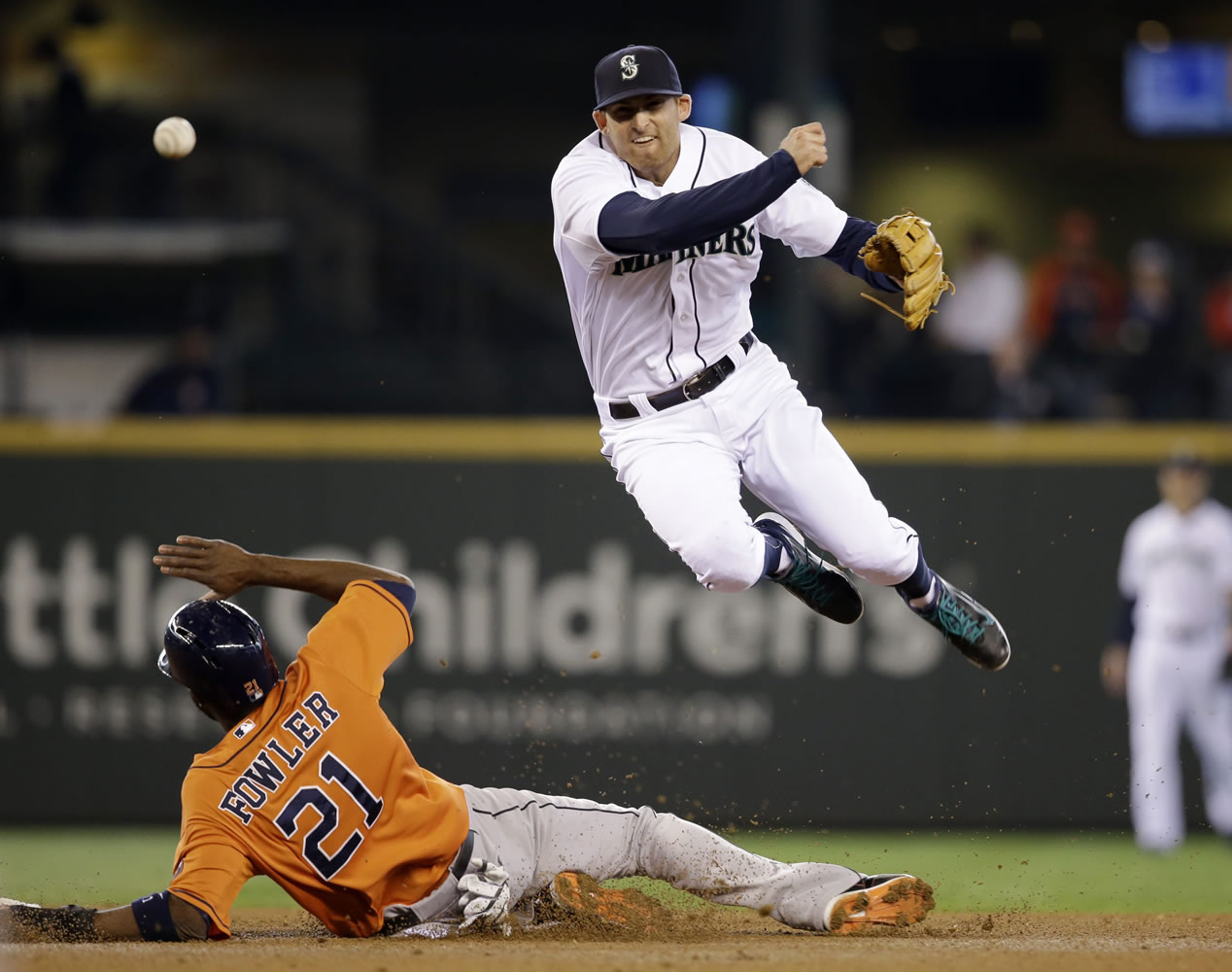 Seattle Mariners shortstop Brad Miller, right, leaps out of the way after forcing out Houston Astros' Dexter Fowler at second base in the fourth inning of a baseball game Sunday, May 25, 2014, in Seattle. Miller completed the play to first for the double play.