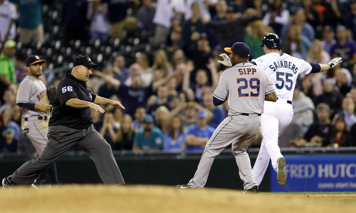 First base umpire Eric Cooper, left, calls Seattle Mariners' Michael Saunders safe at first base with a two-run single just ahead of Houston Astros relief pitcher Tony Sipp in the seventh inning Thursday.