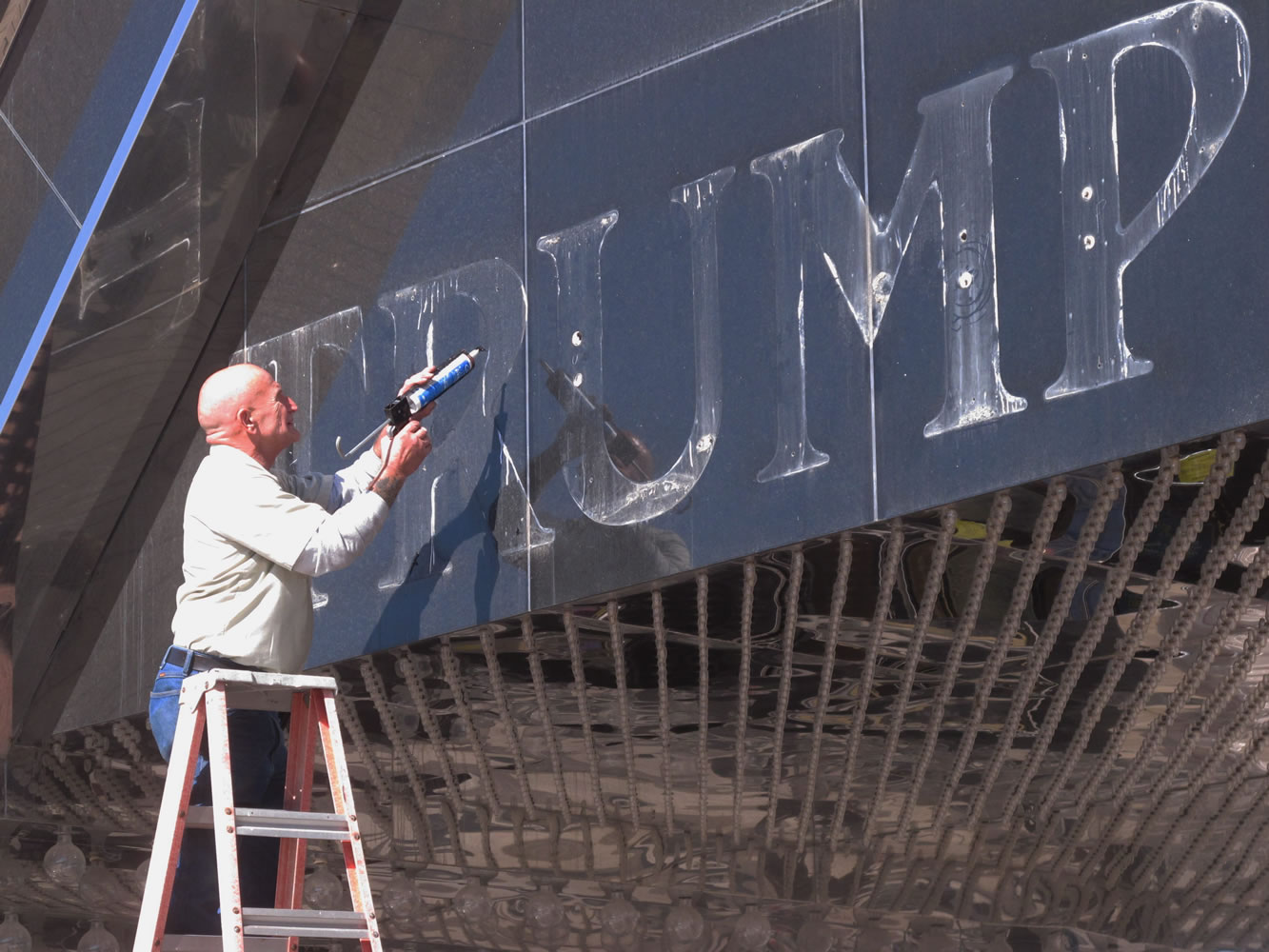 A worker applies caulk to holes in the facade of the former Trump Plaza casino Oct. 6 in Atlantic City, N.J., after letters spelling out the casino's name were removed. The casino closed on Sept. 16, one of four to go out of business in Atlantic City in 2014.