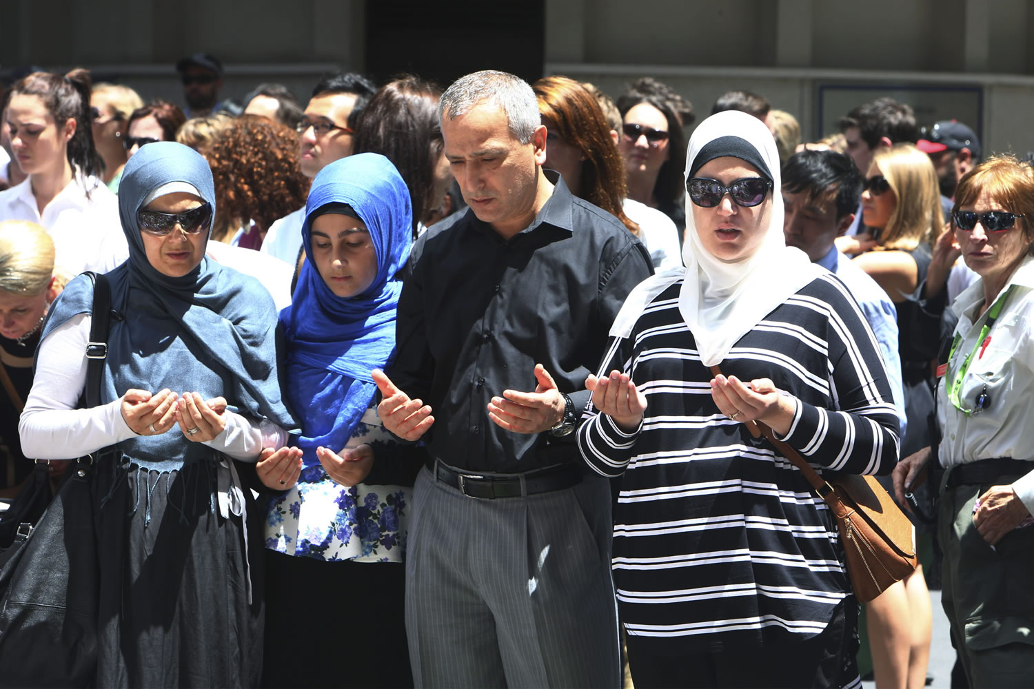 Sydney Muslim community leader Jamal Rifi, center, and his family members pray at a makeshift memorial after a siege at Martin Place in the central business district of Sydney, Australia, on Tuesday.