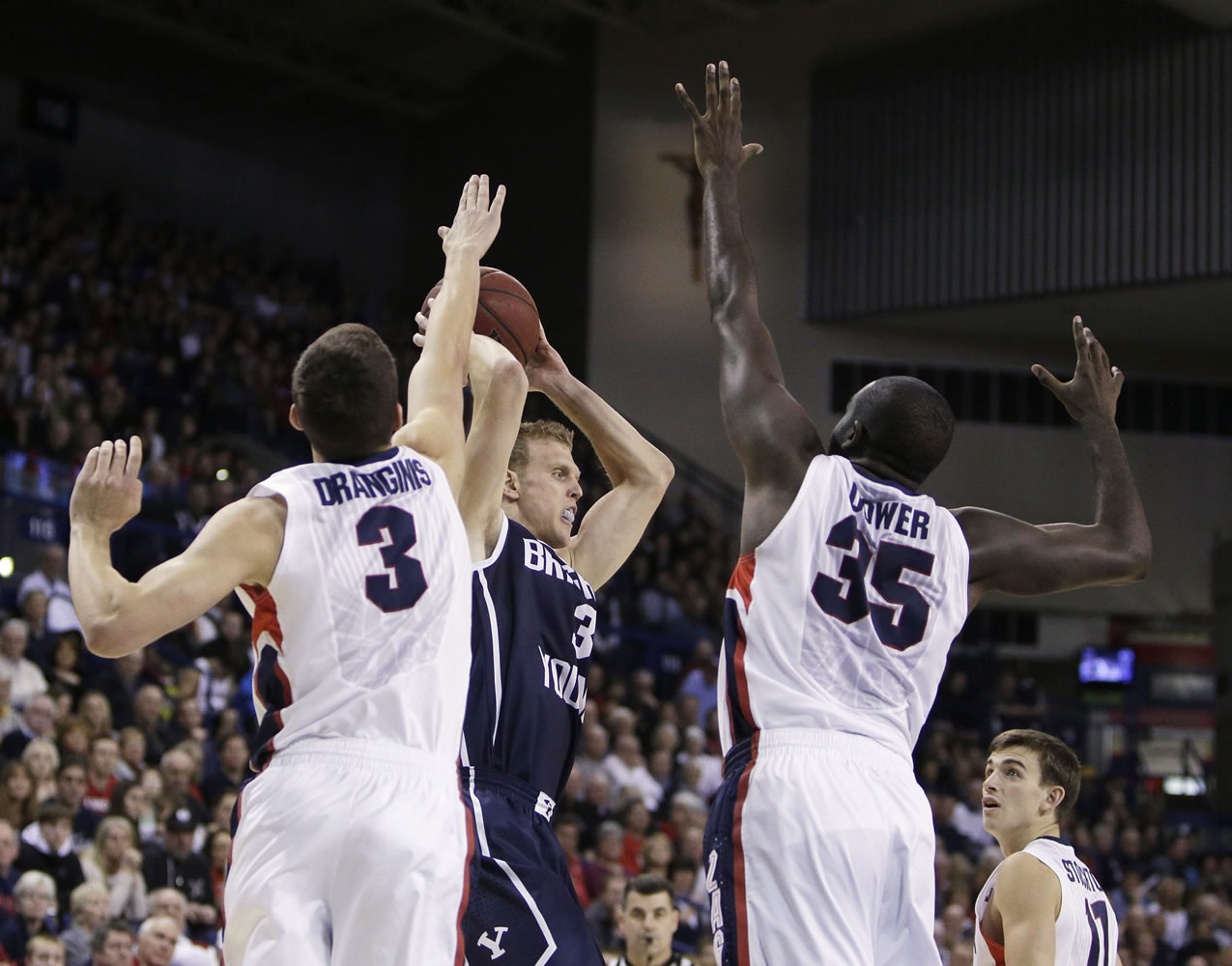 BYU's Tyler Haws (3) looks for a teammate to pass as Gonzaga's Kyle Dranginis (3) and Sam Dower Jr. (35) defend during the first half Saturday in Spokane.