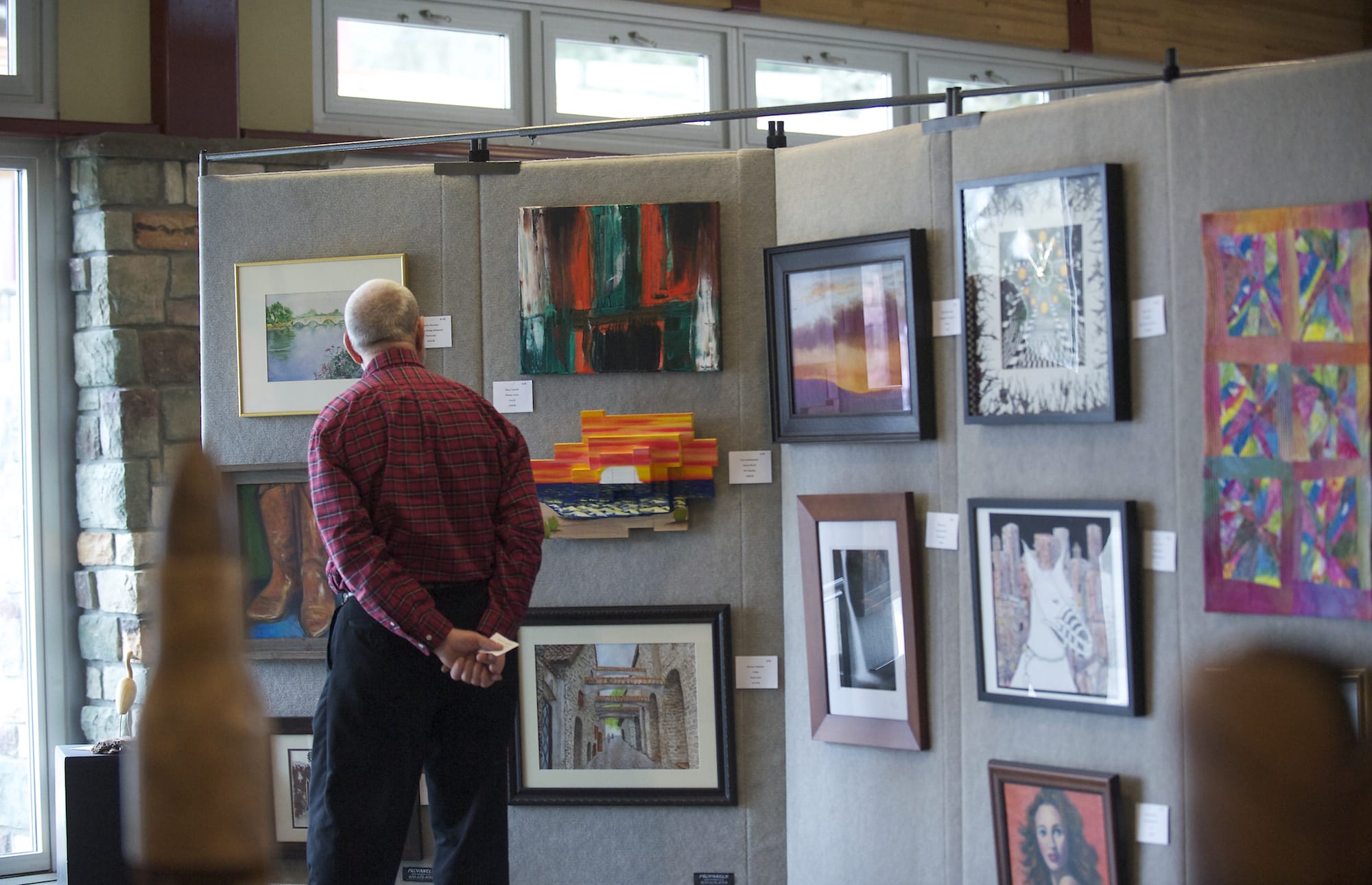 Andy Poole of Amboy looks over artwork last year at the Battle Ground Art Alliance Spring Show and Sale at the Battle Ground Community Center.