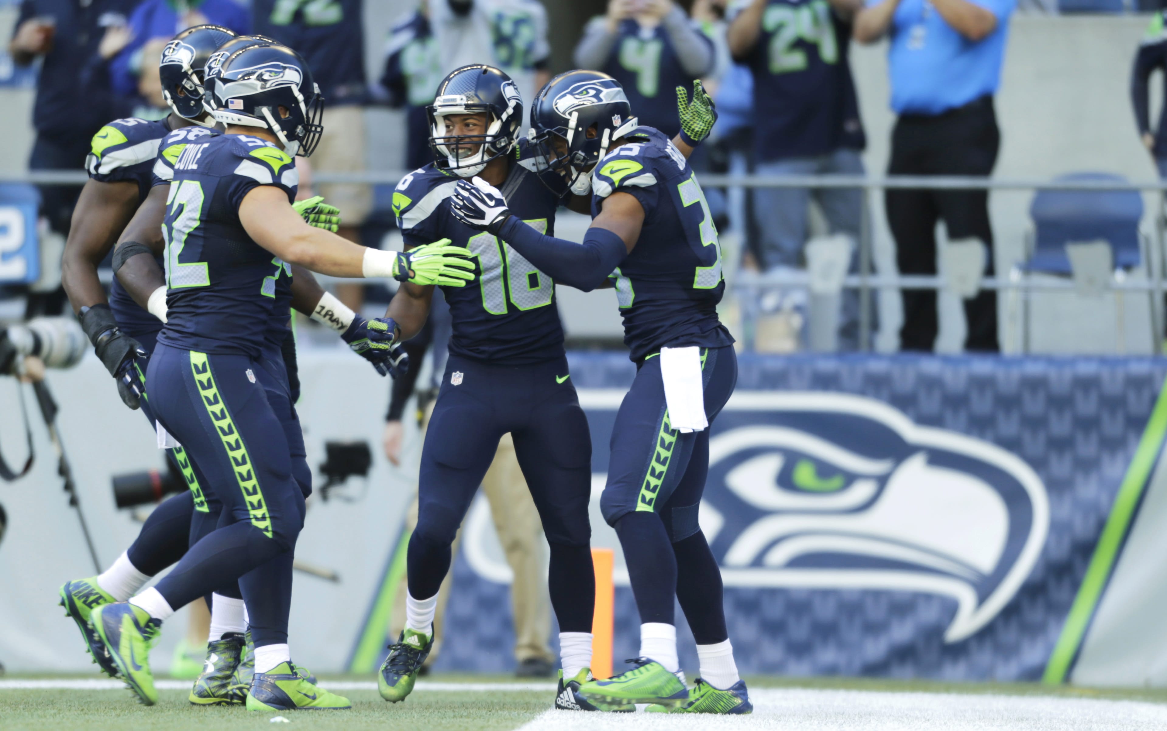 Seattle Seahawks Tyler Lockett, second from right, is greeted by teammates, including DeShawn Shead, right, after returning a Chicago Bears kickoff 105 yards for a touchdown to open the second half  Sunday, Sept. 27, 2015, in Seattle.