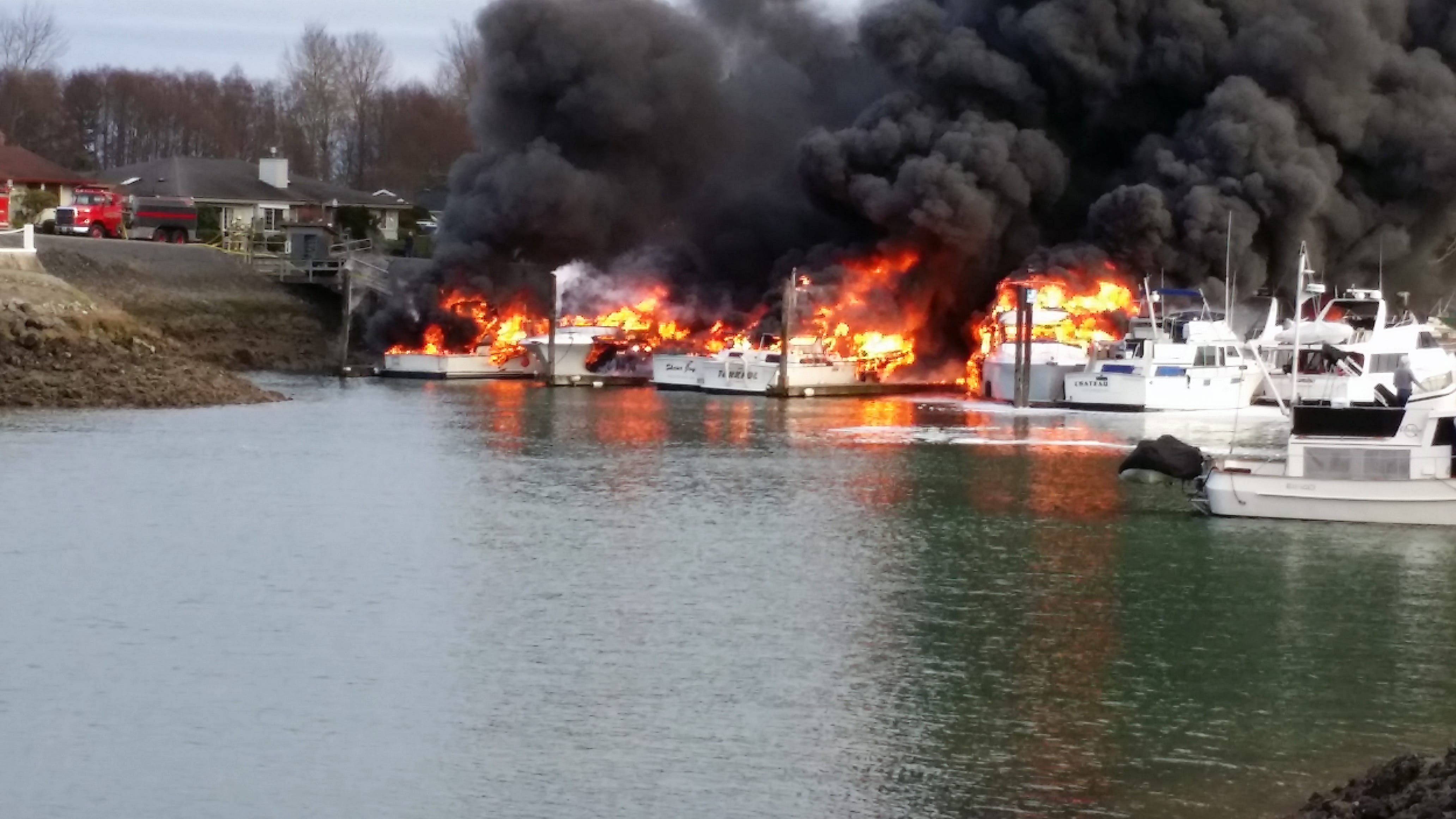 Multiple boats burn at Shelter Bay Marina sending up a huge cloud of black smoke Friday near La Conner. Fire crews poured water on the blazing boats from land and from a fireboat. There were no reports of injuries.