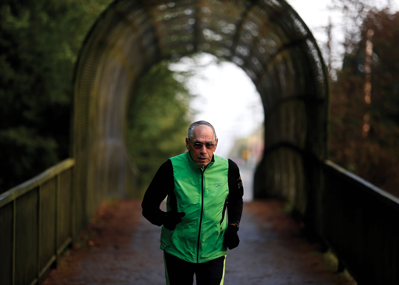 Bill Iffrig, 79, runs across an old footbridge early Friday morning in Everett.