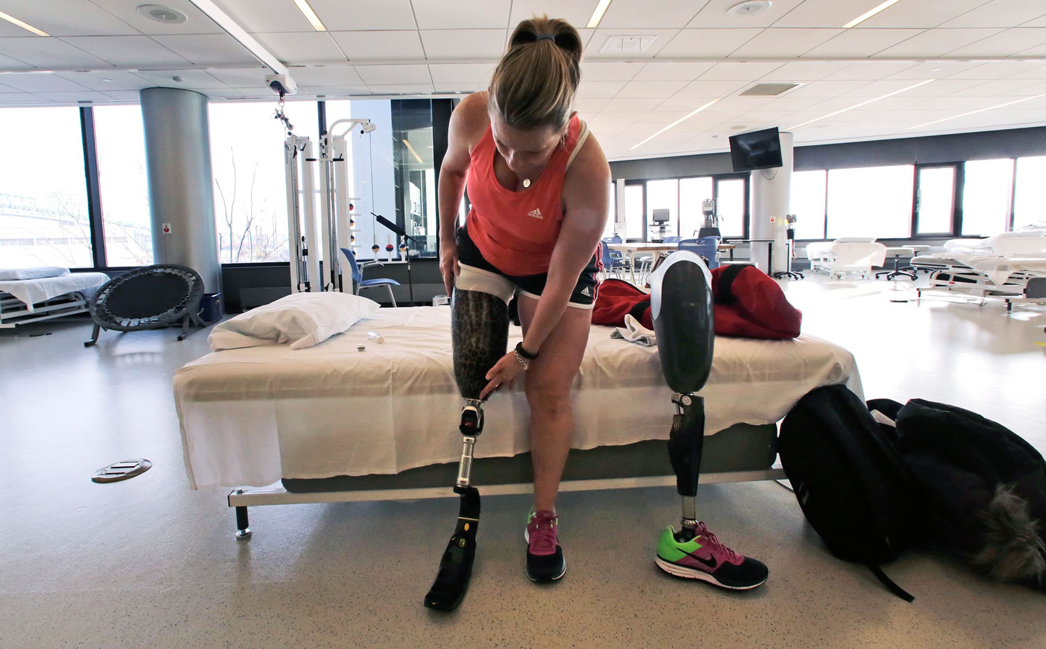 Photos by CHARLES KRUPA/Associated Press
Boston Marathon bombing survivor Roseann Sdoia adjusts her running blade as she switches her prosthetic legs during a therapy session March 11 at the Spaulding Rehabilitation Hospital in Boston. Sdoia, a runner who did not take part in the last year's Boston Marathon, was in a crowd of fans near the finish line when one of two bombs went off nearby.
