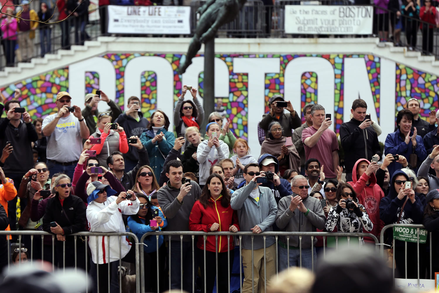 Race fans photograph and cheer for runners competing in the 118th Boston Marathon on Monday in Boston.