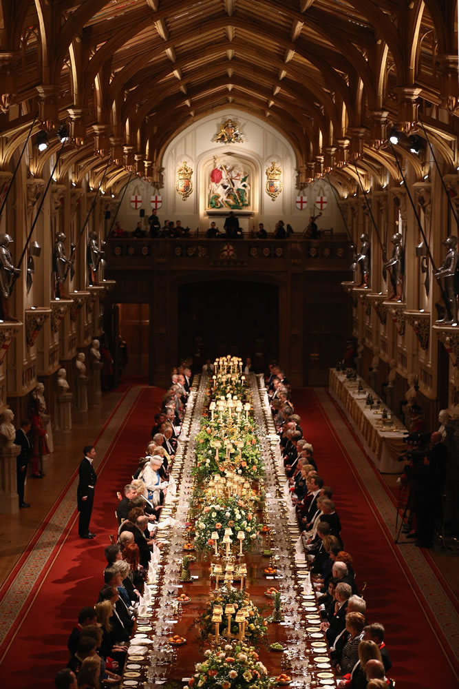 Guests listen during a speech by Britain's Queen Elizabeth II, center on left side of table, during a state banquet in honor of Irish President Michael D.